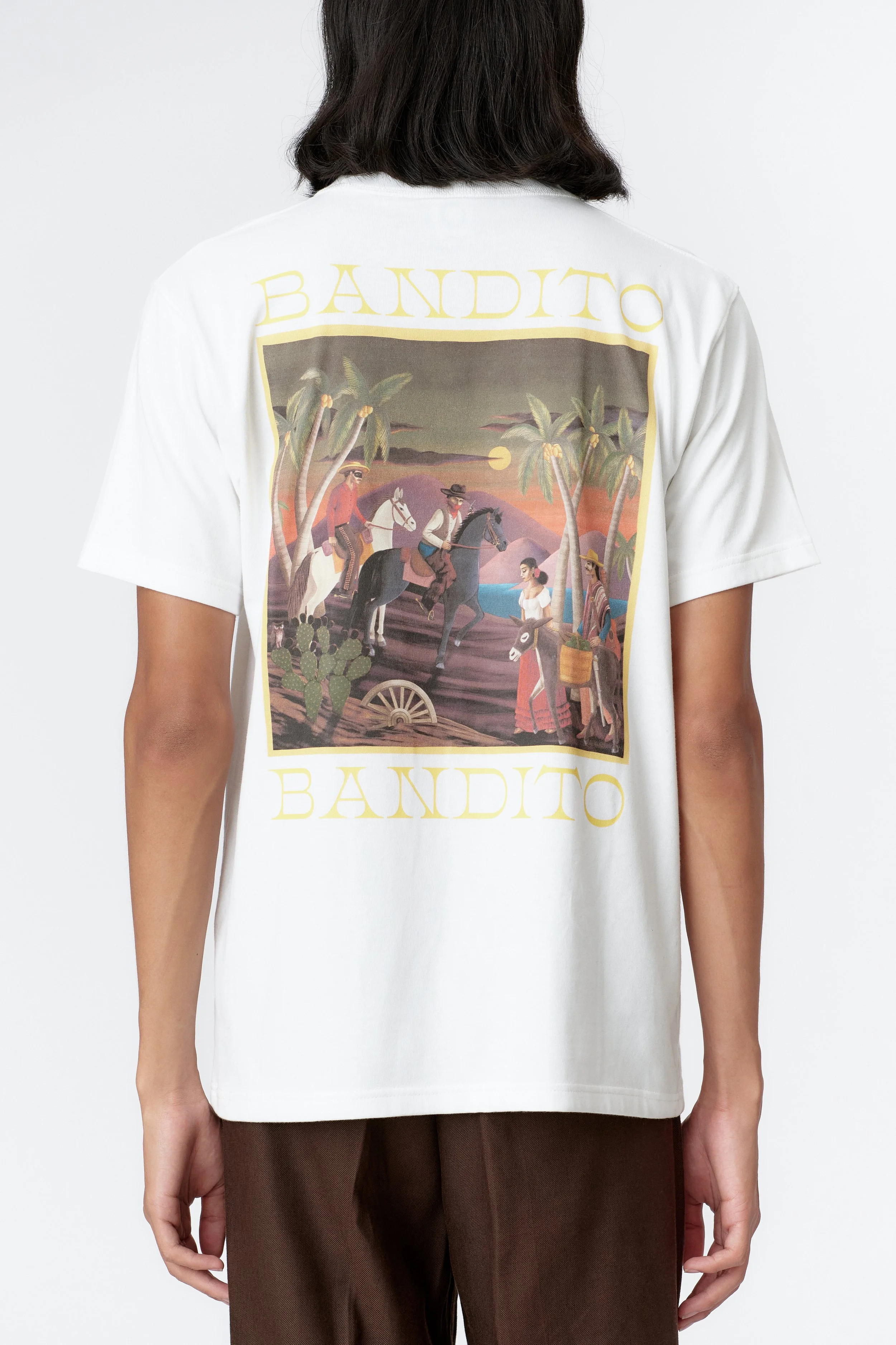 Close-up of back print showing palm trees and split-tone sky in vivid orange and green