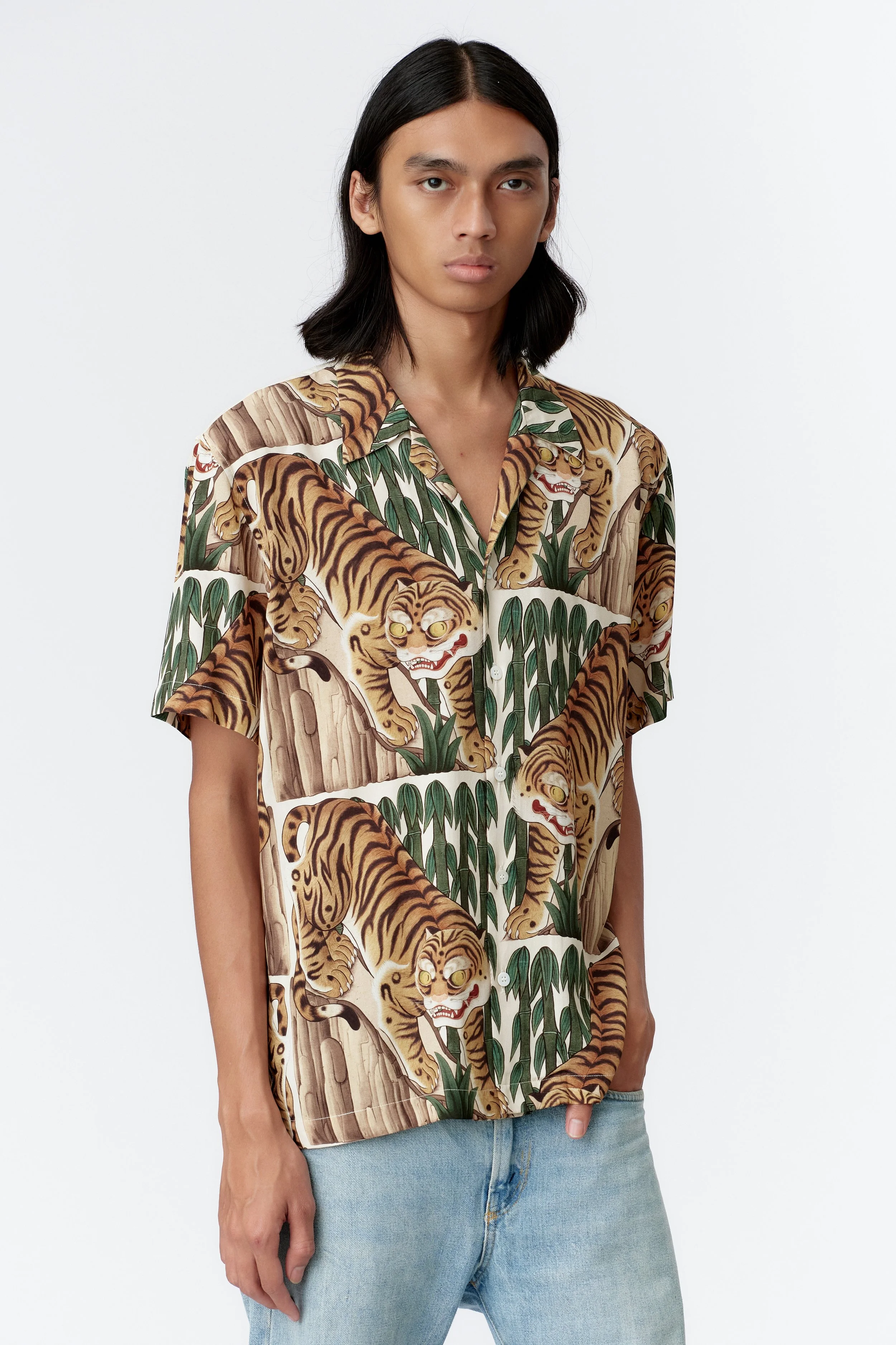 Chest detail showing green bamboo leaves and decorative motifs on cream base of endless joys tiger shirt