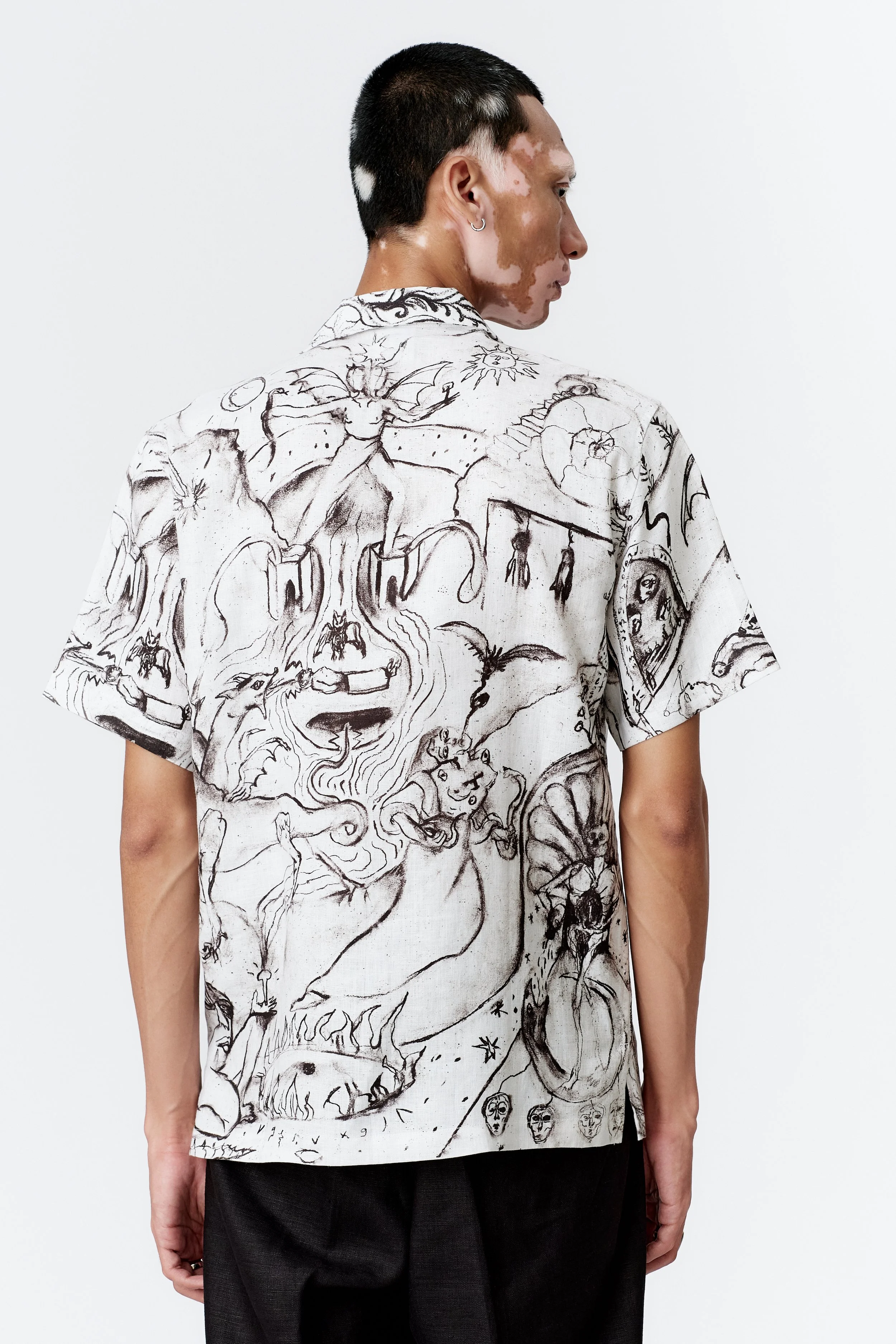 Rear close-up of black-and-white ALCHEMY linen shirt illustrating intricate sketchwork and alchemical motifs