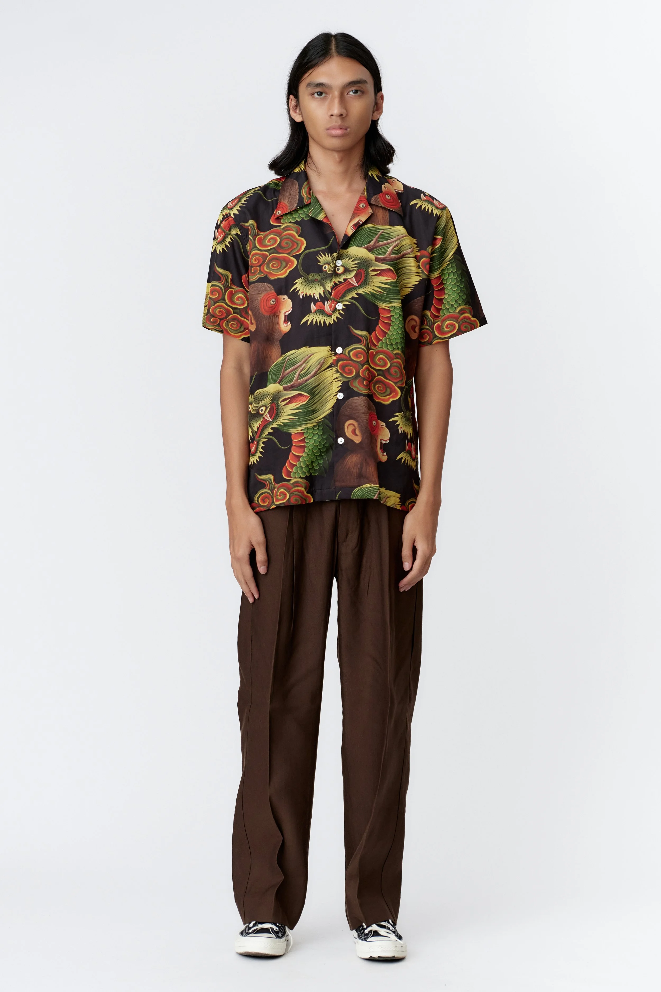 Full-length model image wearing Monkey Dragon Black short sleeve shirt showing straight hem and natural fabric drape.