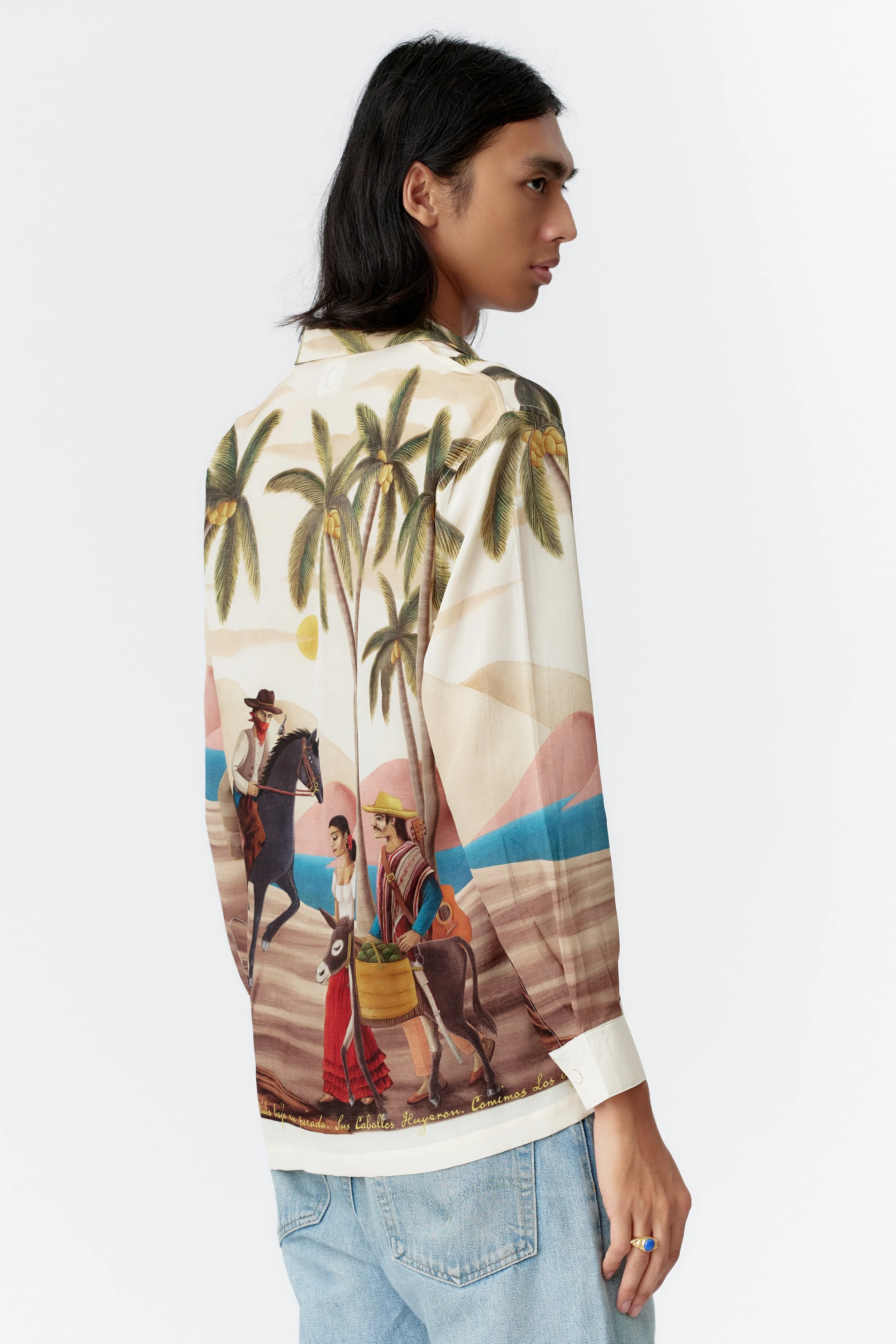 Three-quarter angle of model wearing Bandito Off White limited edition silk crepe shirt highlighting relaxed fit and artwork placement.