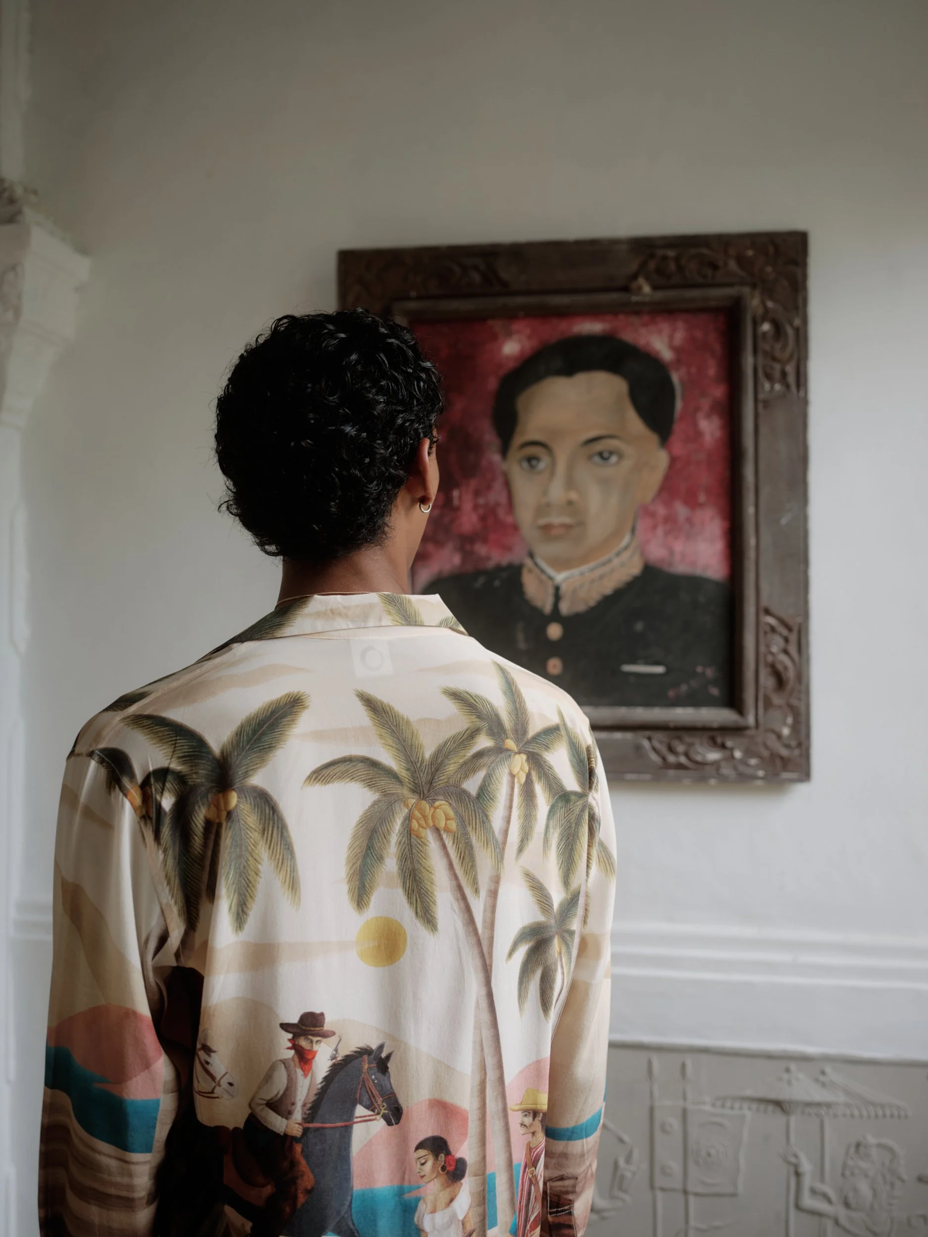 model wearing bandito artwork while viewing an artwork painting in bali