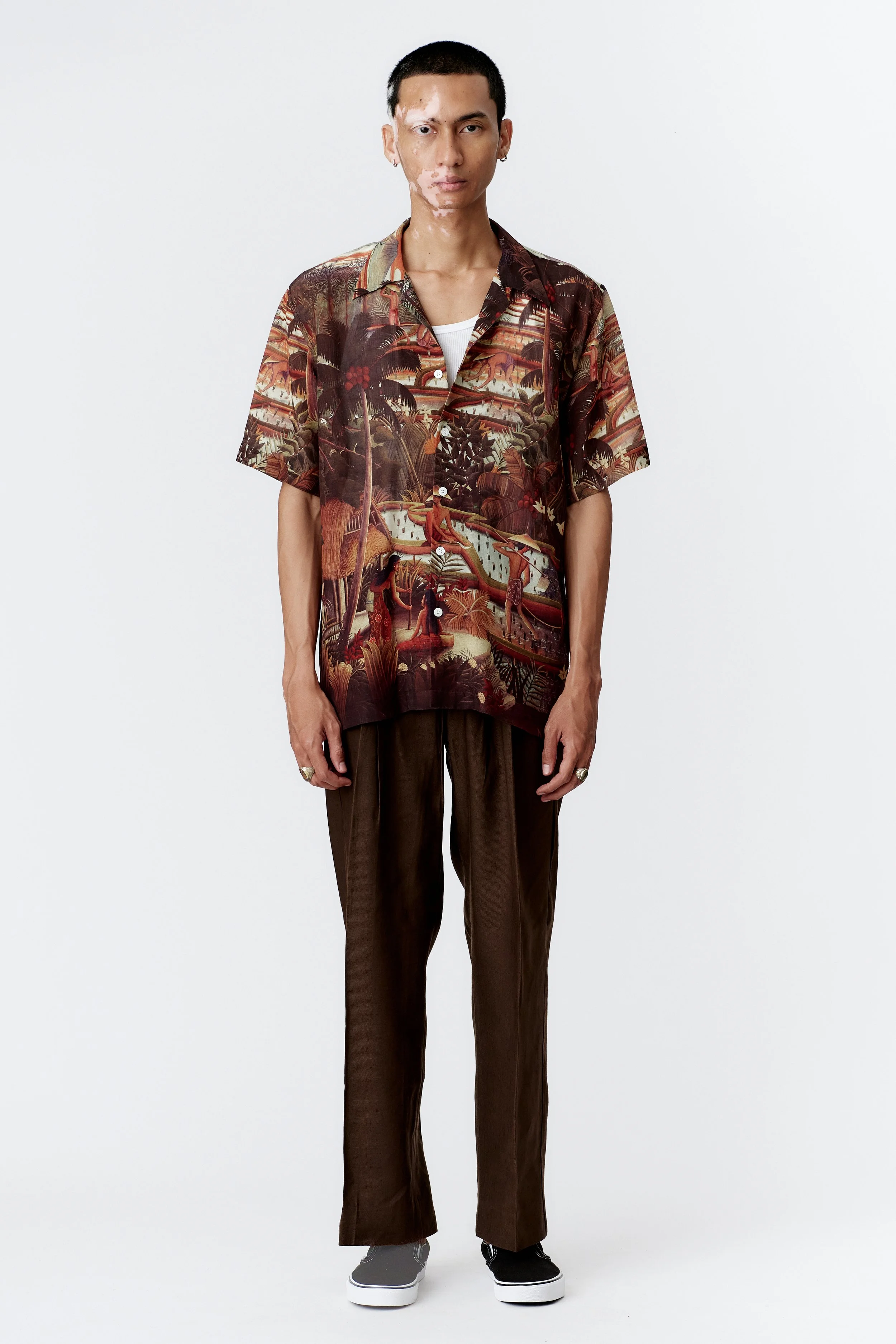 Full view of model wearing Subak brown silk rayon shirt with straight hem styled with brown trousers
