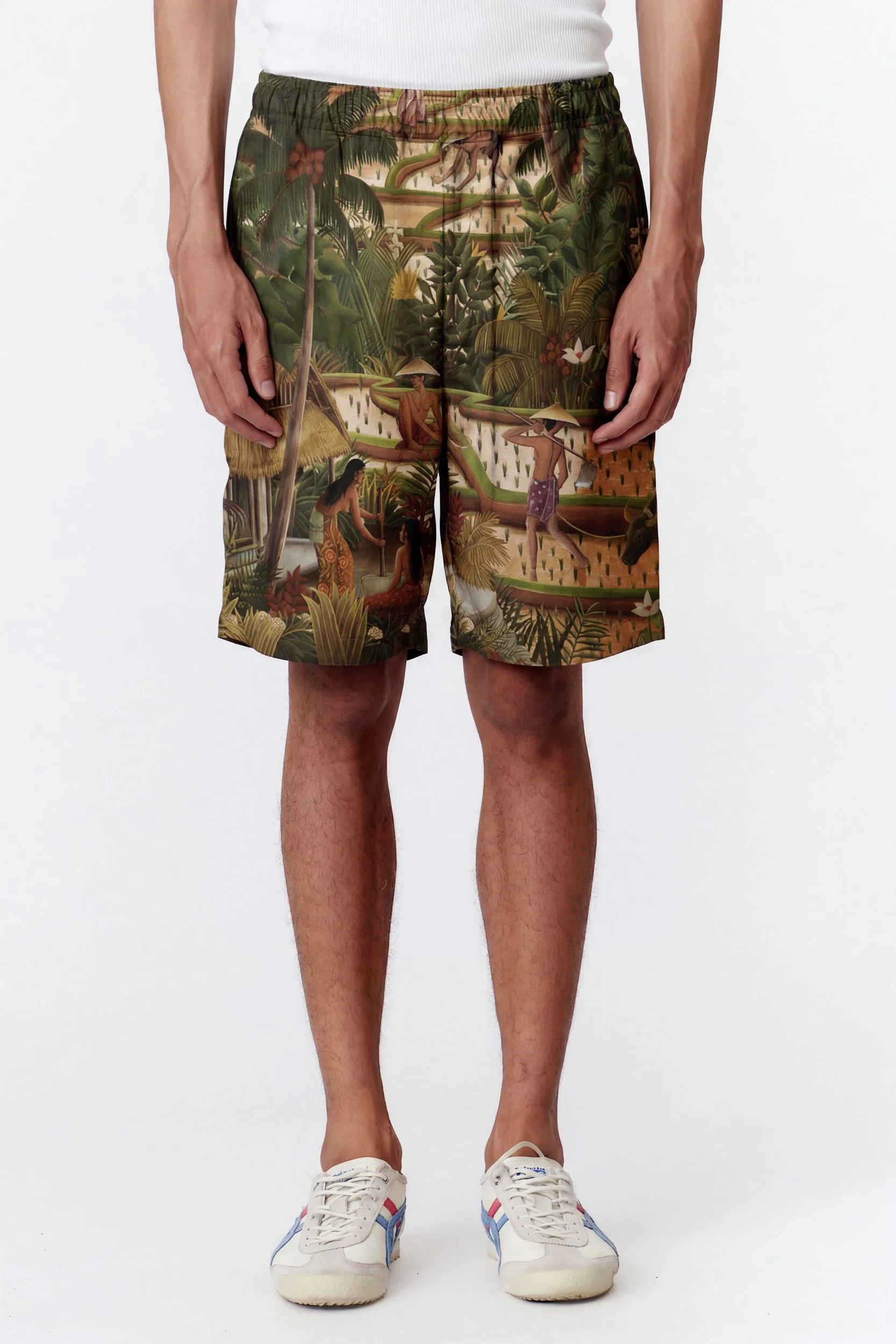 Close-up of Subak Green premium rayon board shorts showing hand-painted Stevie Anderson artwork and fabric texture, handmade in Bali