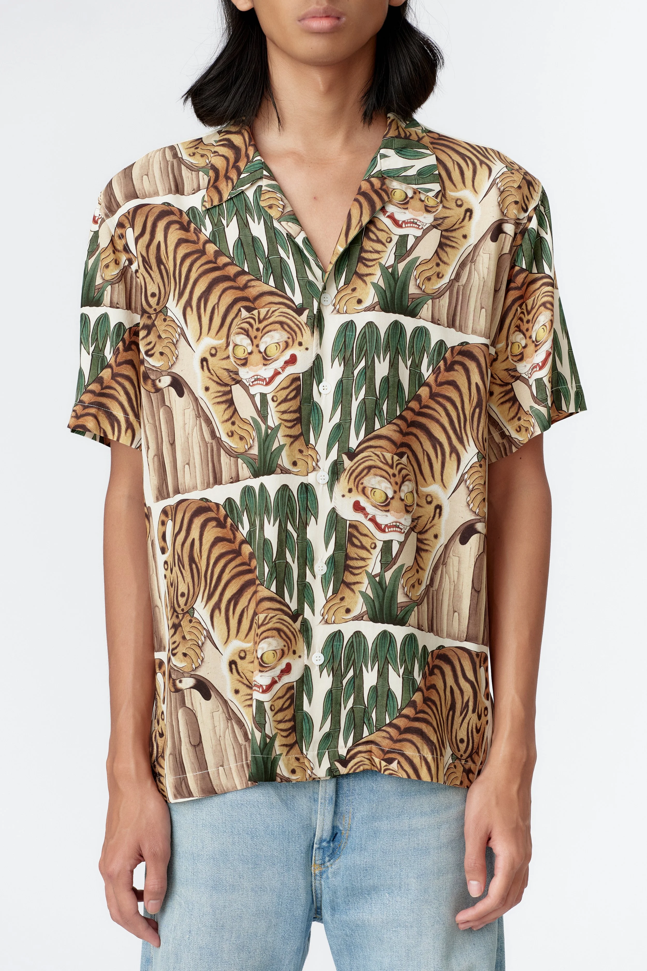 Close-up detail of prowling orange tiger with yellow eyes on cream rayon fabric