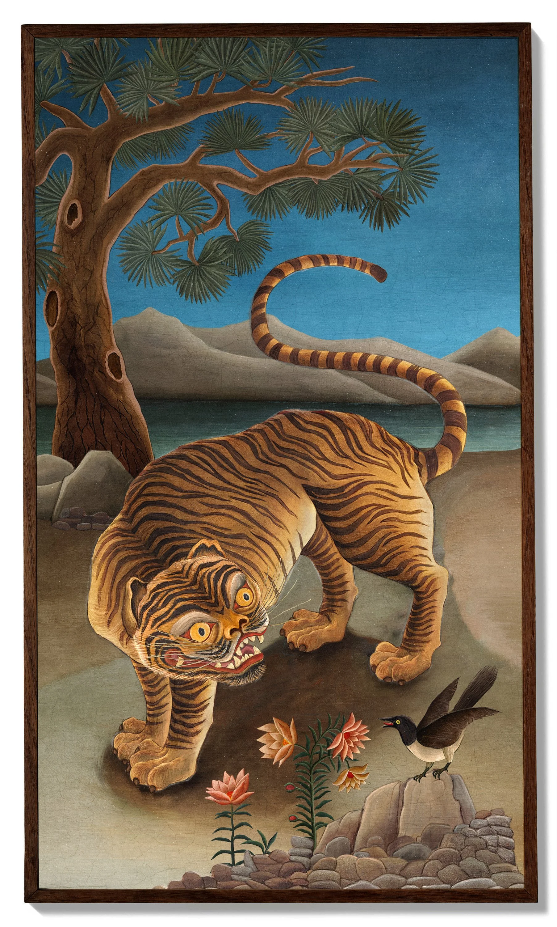 A painting of a tiger with a fierce expression, large eyes, and bared teeth, standing on a rocky ground. There is a bird with black and white feathers standing on a rock nearby. A large tree with green leaves and a body of water with mountains in the background are also visible.