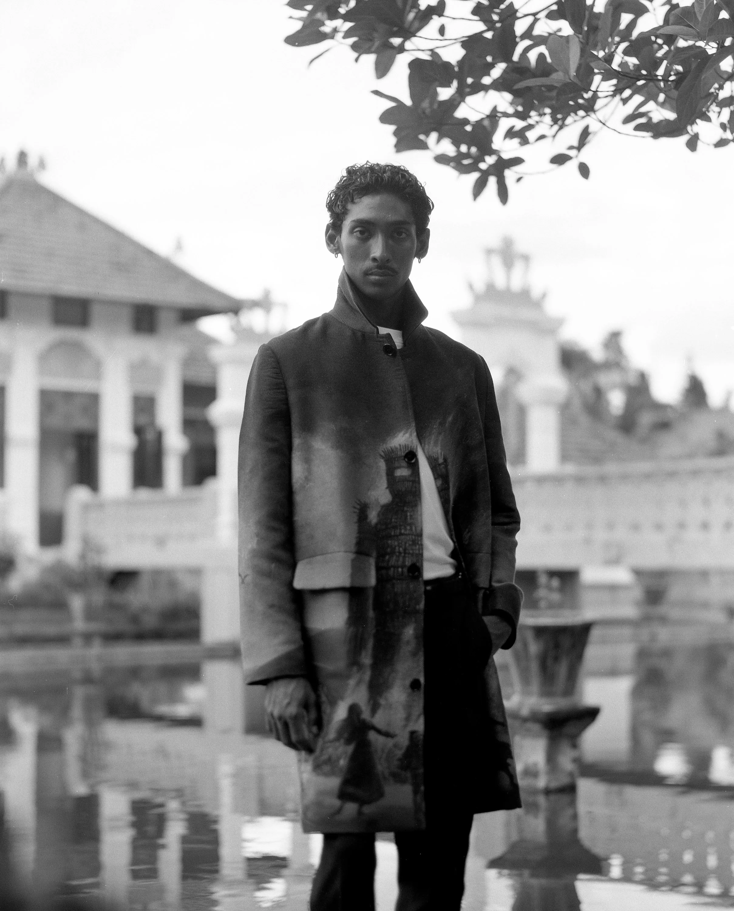 viknes wearing overcoat with burning wickerman woven artwork at kings water palace in bali