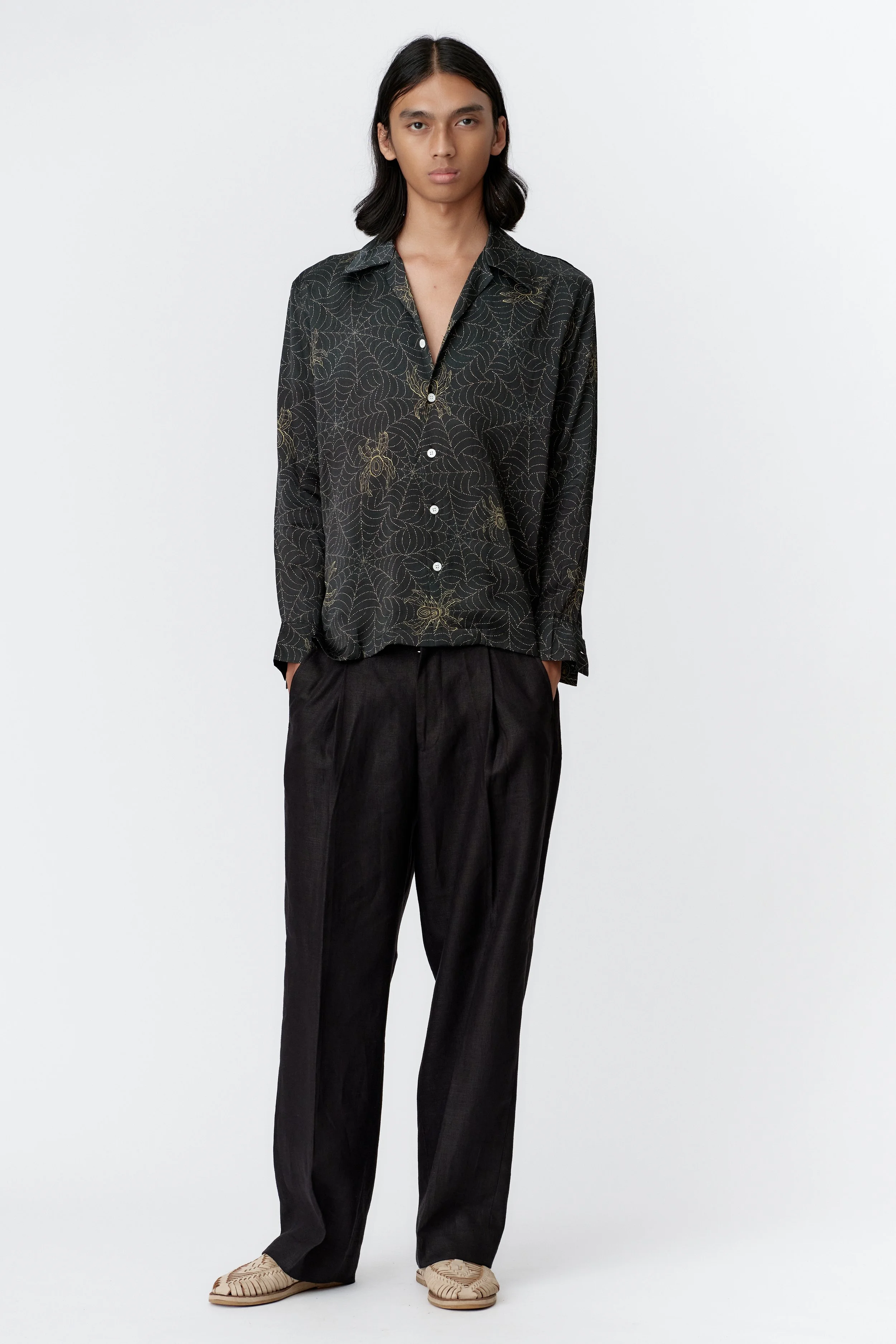 Front view of Spiderweb Indigo silk satin long sleeve shirt with golden batik-style spiderweb pattern and camp collar.