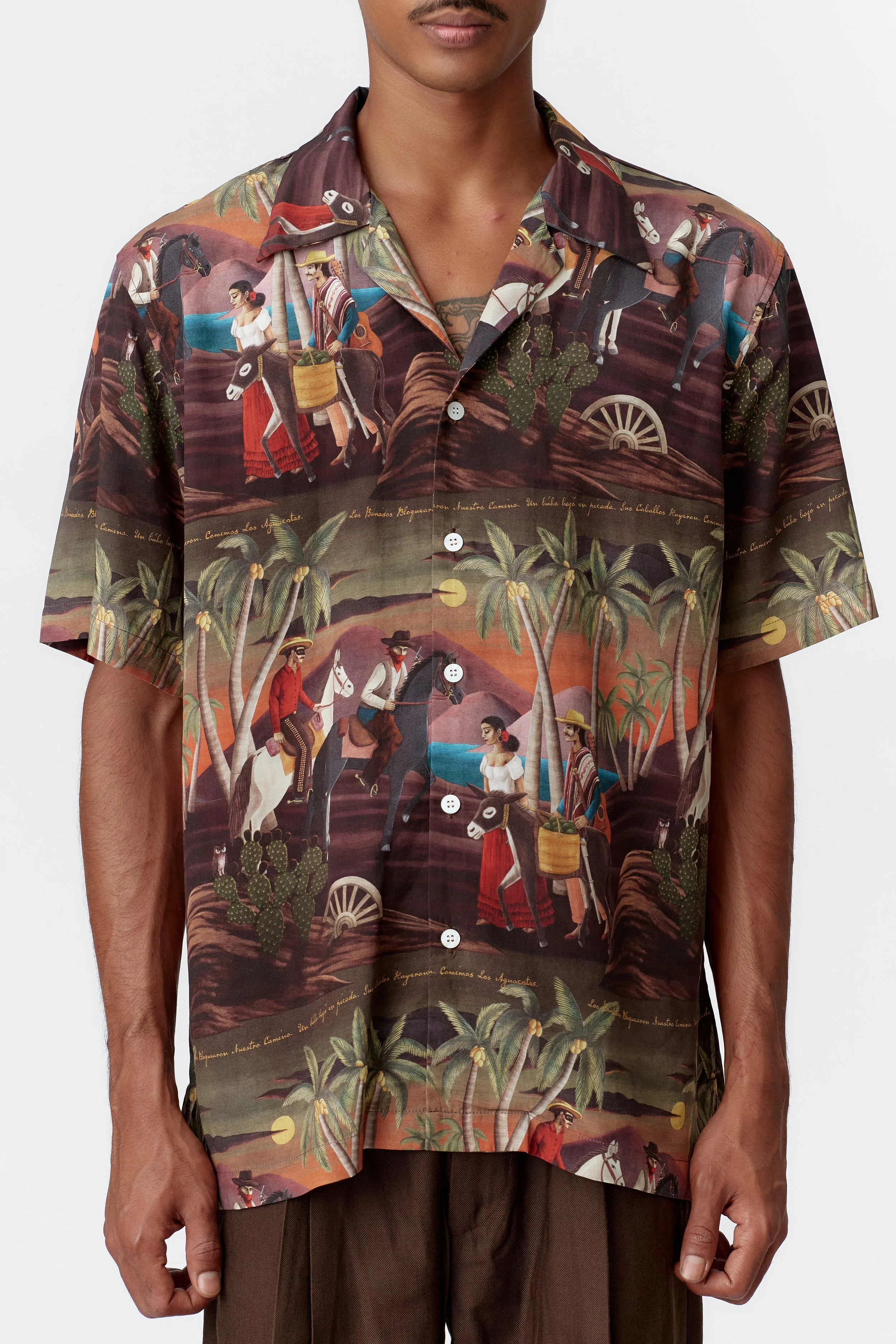 Close-up of repeat pattern artwork on bottle green fabric featuring cowboys, farmer, and donkey scene