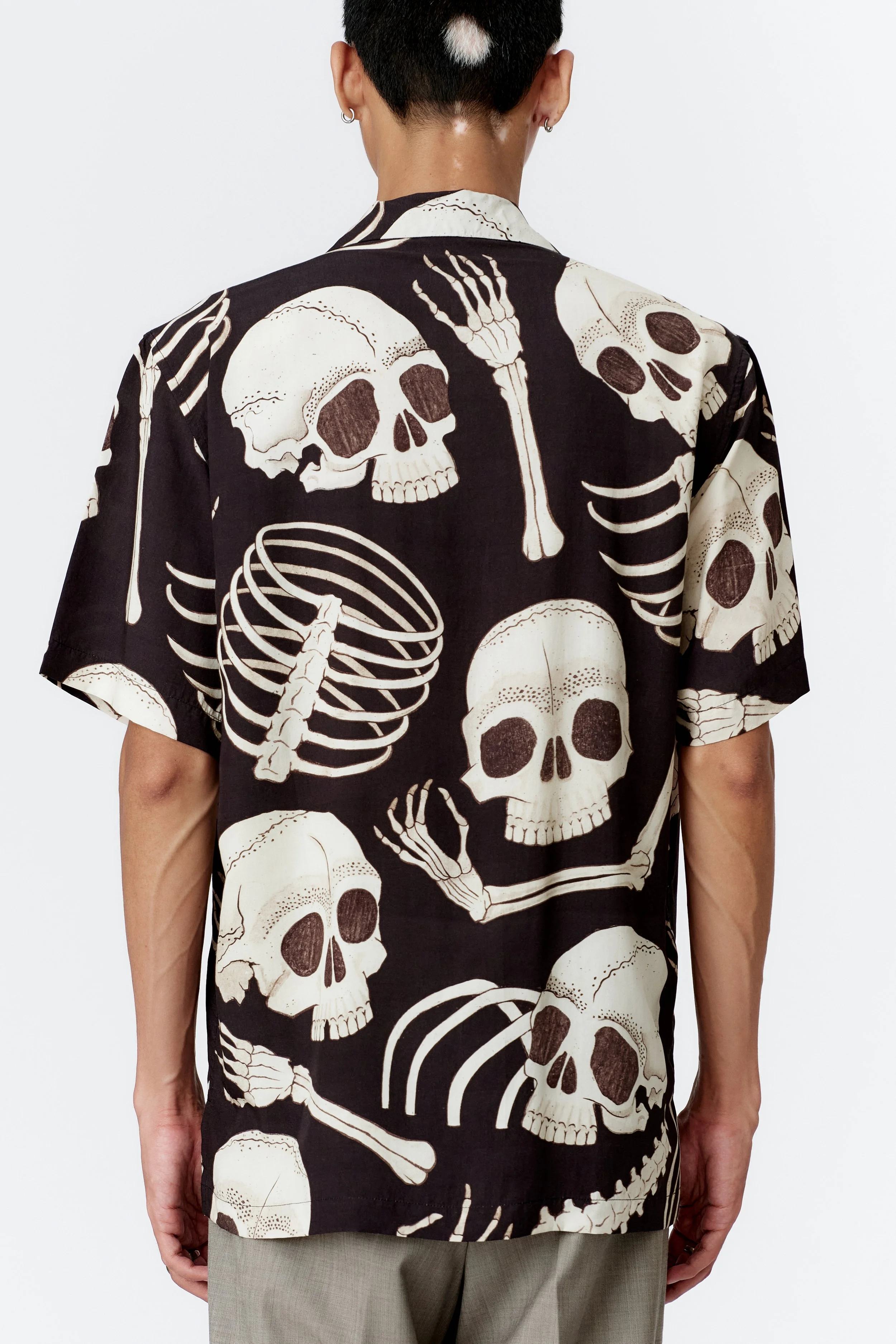 Back view of black Skeleton shirt featuring oversized skull and bone illustration
