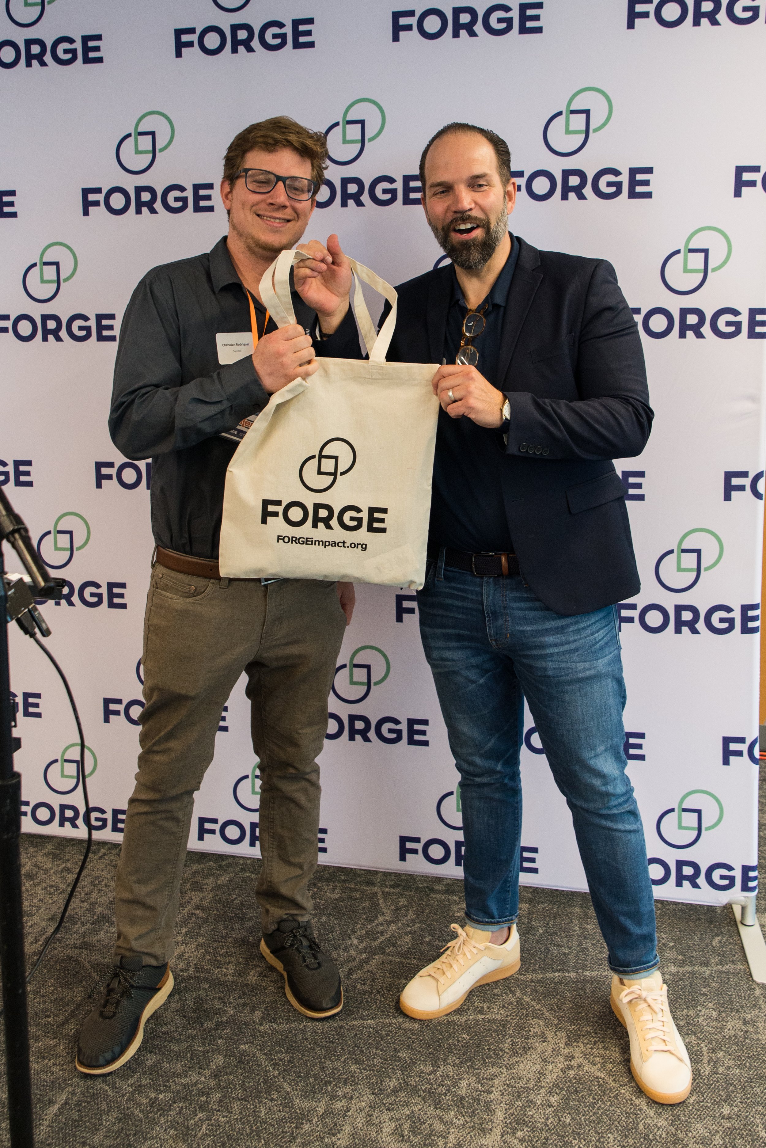  Samtec Field Application Engineer Christian Rodriguez and FORGE Vice President Adam Rodrigues pose with one of the swag bags of Connecticut-made products  