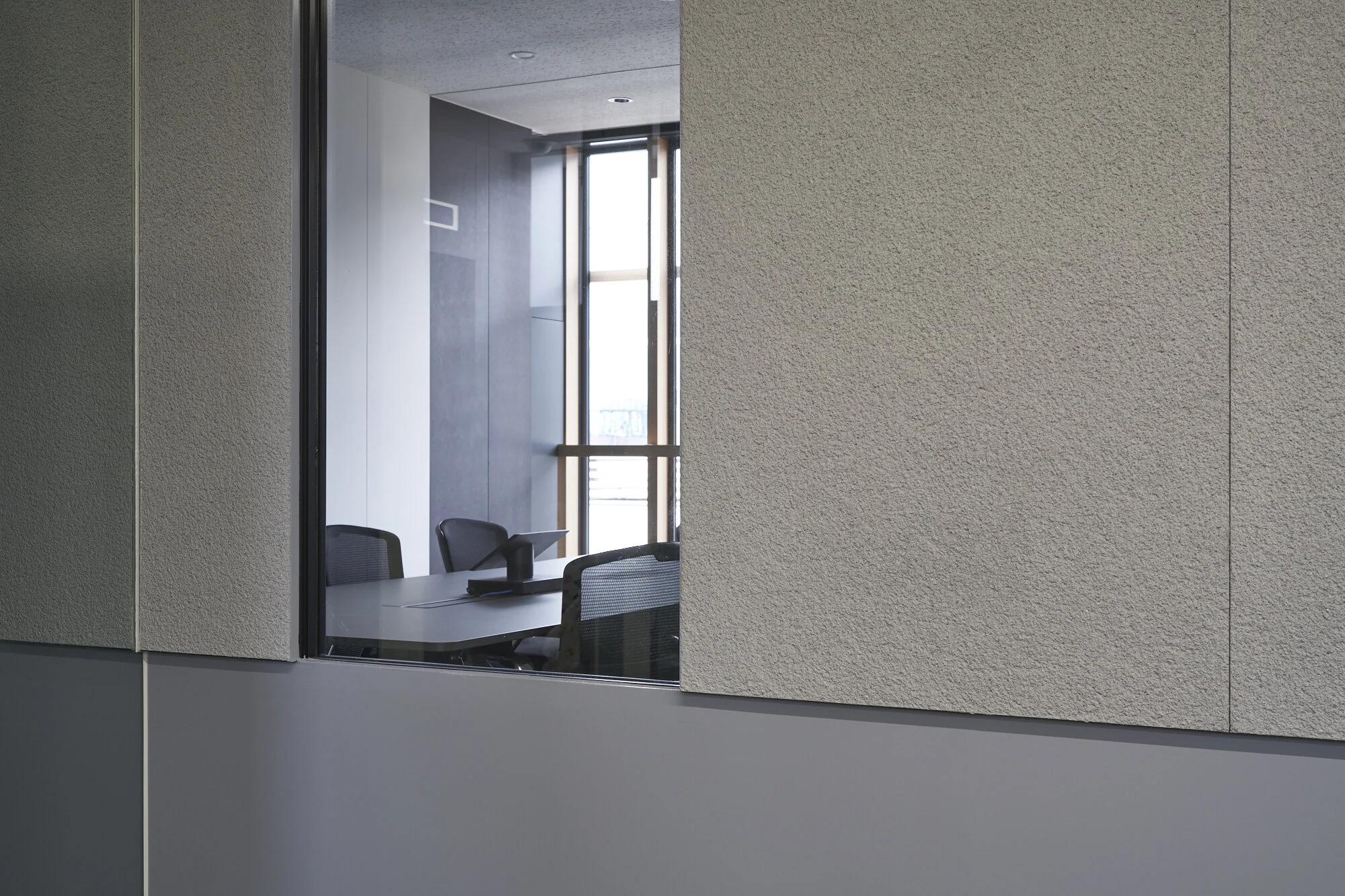  < SILQ Capital office >  東京にある資産運用会社の新オフィスの内装デザイン計画である。  企業の性質上、信頼・高級感とベンチャー企業としてのフレッシュさ、秘匿性と解放感といった、一見矛盾するような要素の両立が求められる中、既存空間は植栽を配置したテラスや、木目調のサッシといった、強い性格を既に持っていた。  そこで、セキュリティーを求められる個室空間を既存壁面の延長として挿入し、エレベーターホールから執務空間を通して外部のテラスが見えるように空間形状を整理した。  意匠面においては、荒く掻き落とされたモルタルと艶の無い塗装といった、対極な性格を持つテクスチャーをワントーンでまとめた壁面仕上げや、外部の色を取り込むようなカーペット等、既存空間の意匠との整合性をとりつつ、本質的な素材感による高級・信頼感と企業のフレッシュさを両立させることを試みた。  