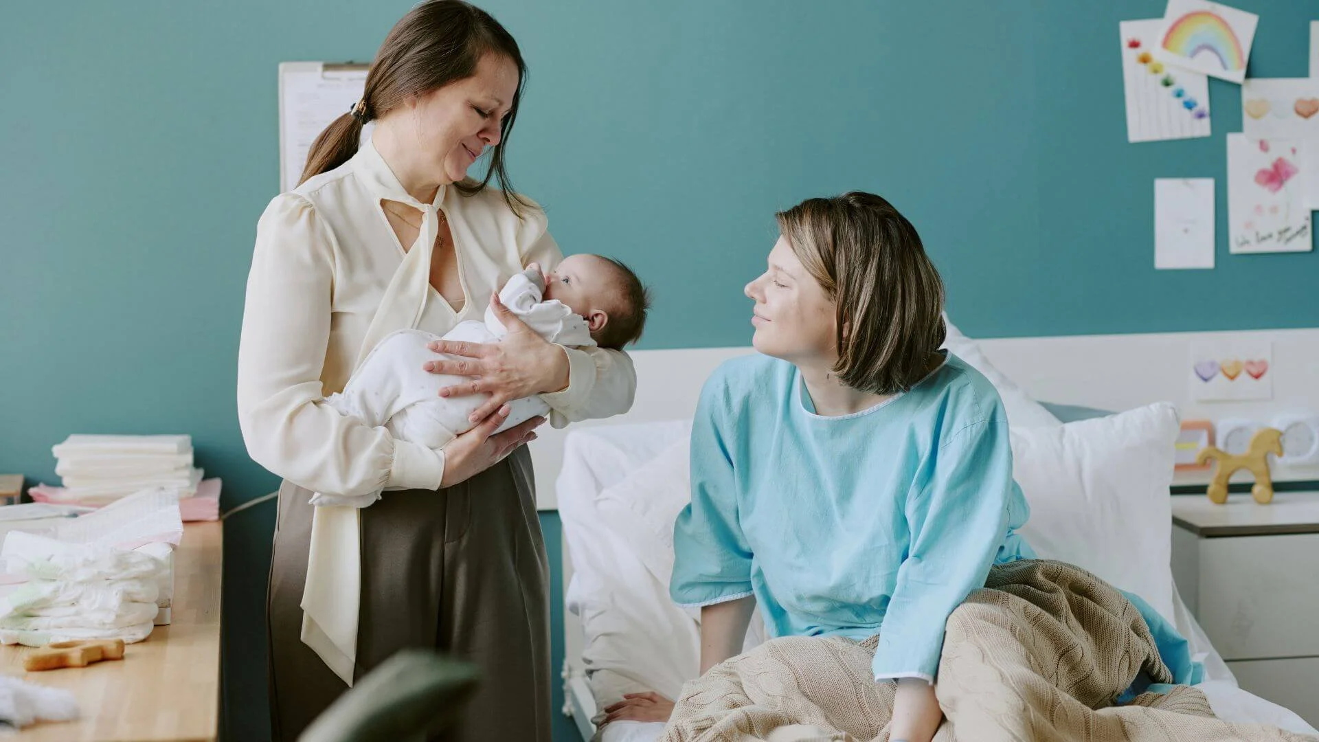 a postpartum doula holding a newborn