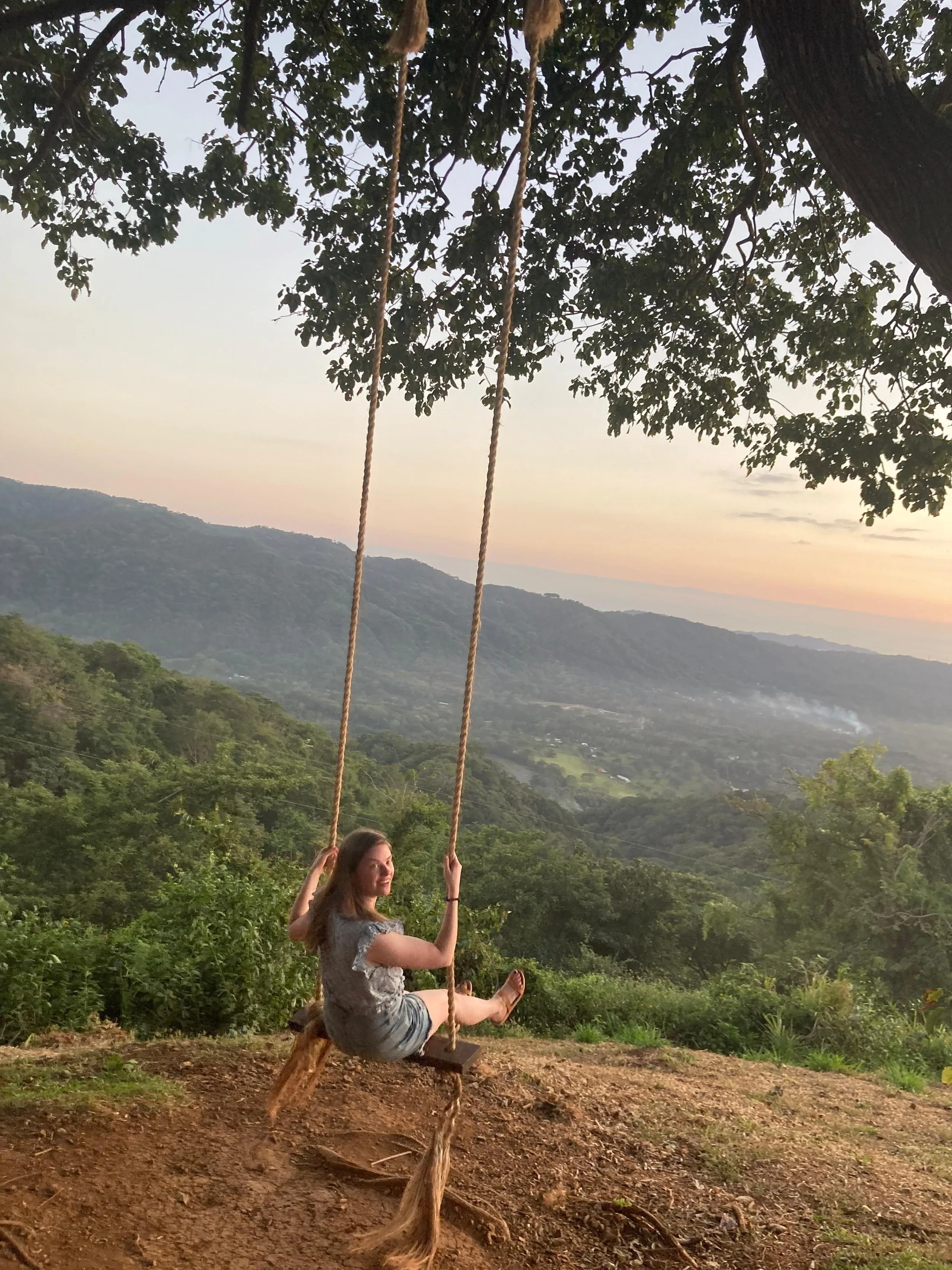 Woman swings on a swing at Coyol restaurant in Nosara, Costa Rica.