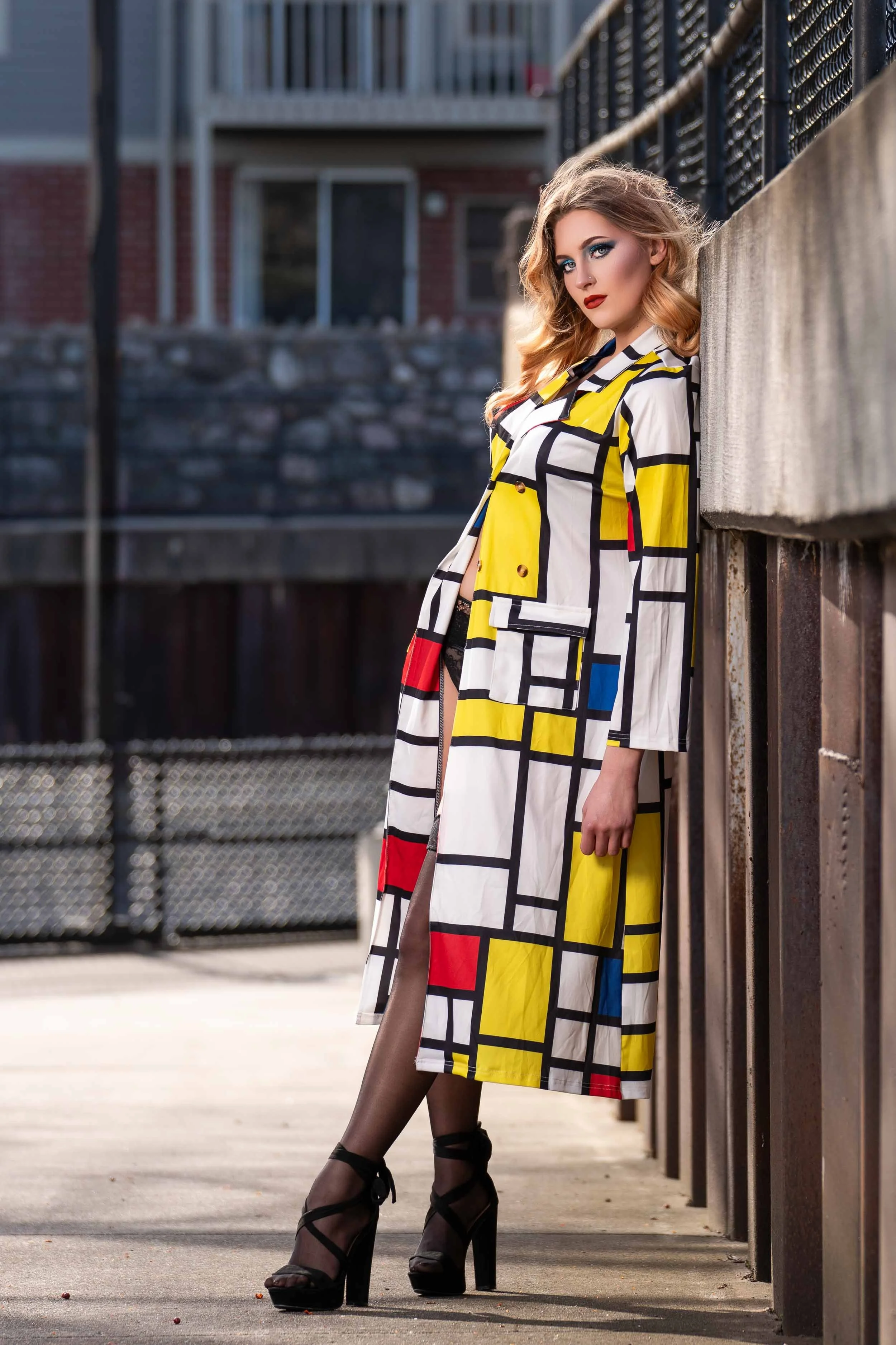 Editorial fashion photography in urban downtown South Bend, Indiana, featuring a model in a bold geometric coat.