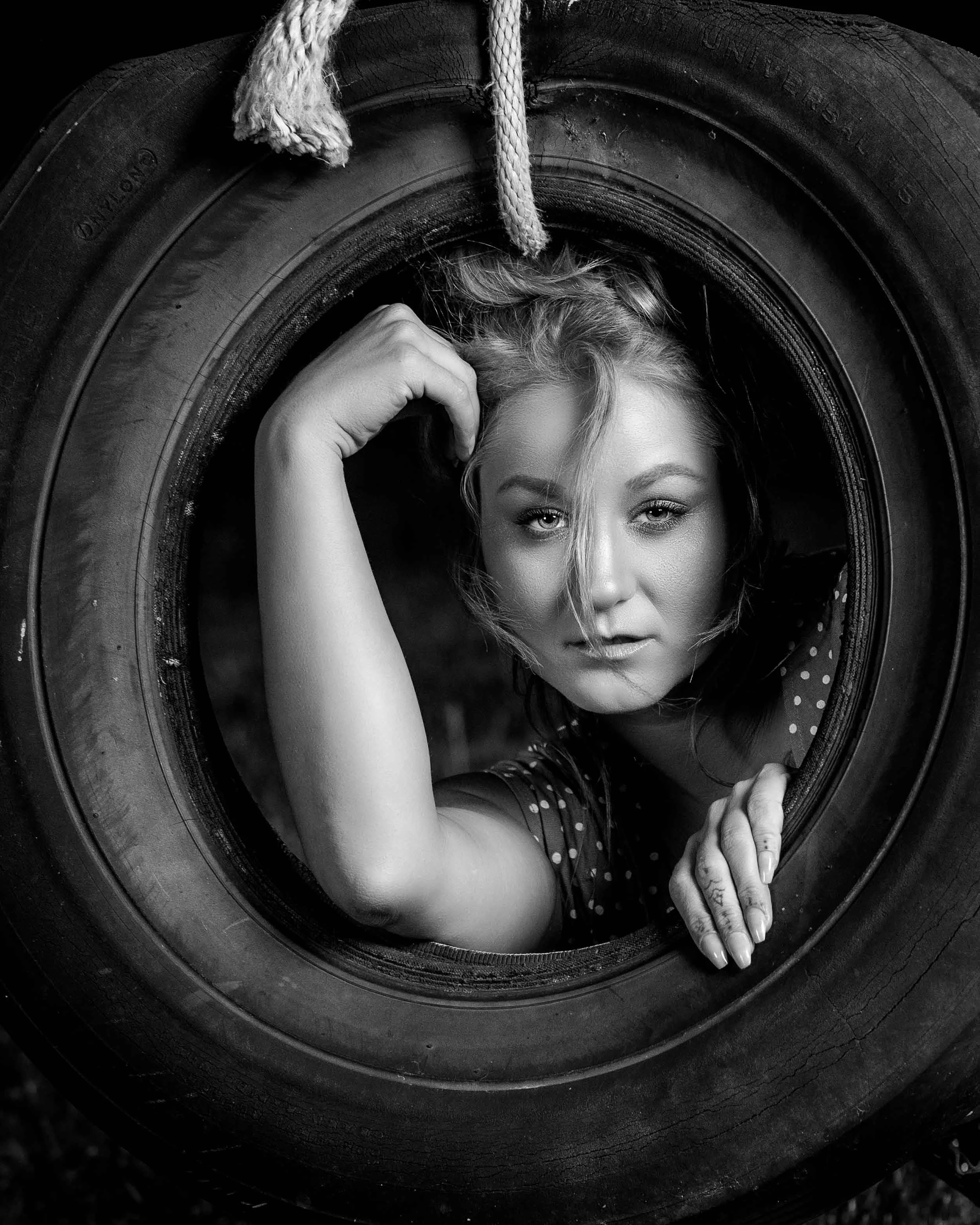 Creative fine art portrait by Northern Indiana photographer James Russell, featuring a model posed inside a hanging tire.