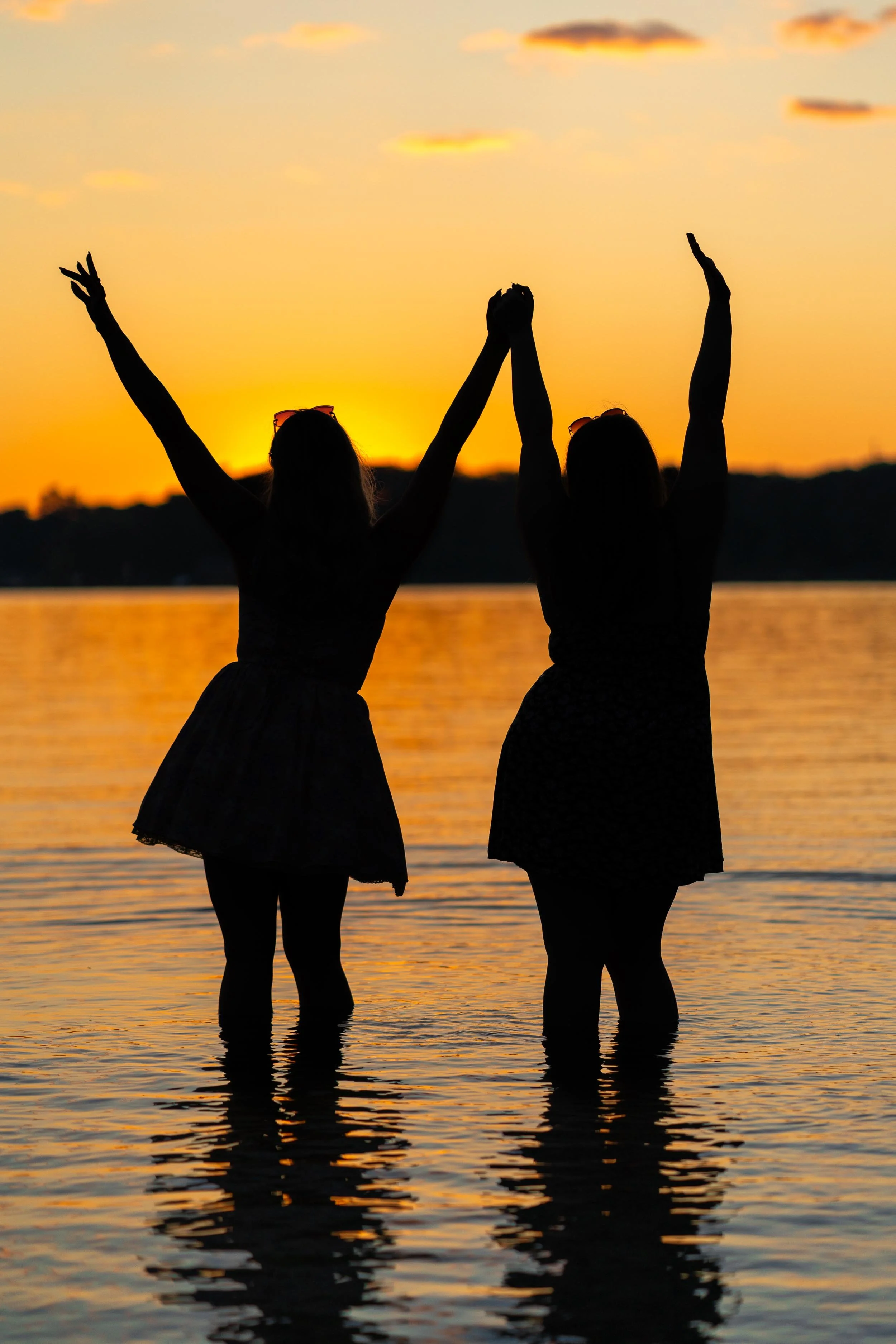 Silhouette of best friends at sunset on a Lake Michigan beach in Southern Michigan.