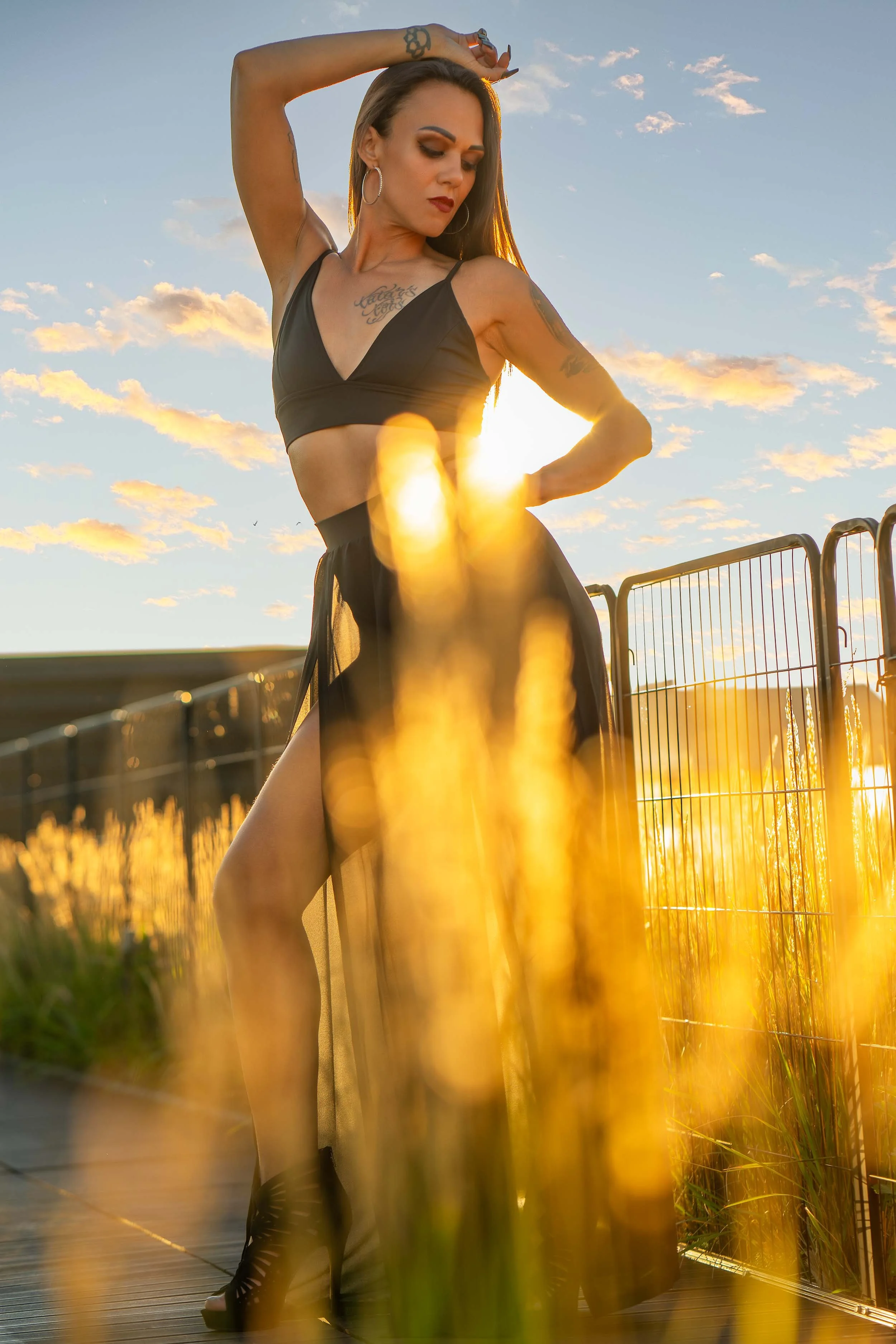 A fashion model in a black outfit posing during a golden hour sunset session in Northern Indiana.
