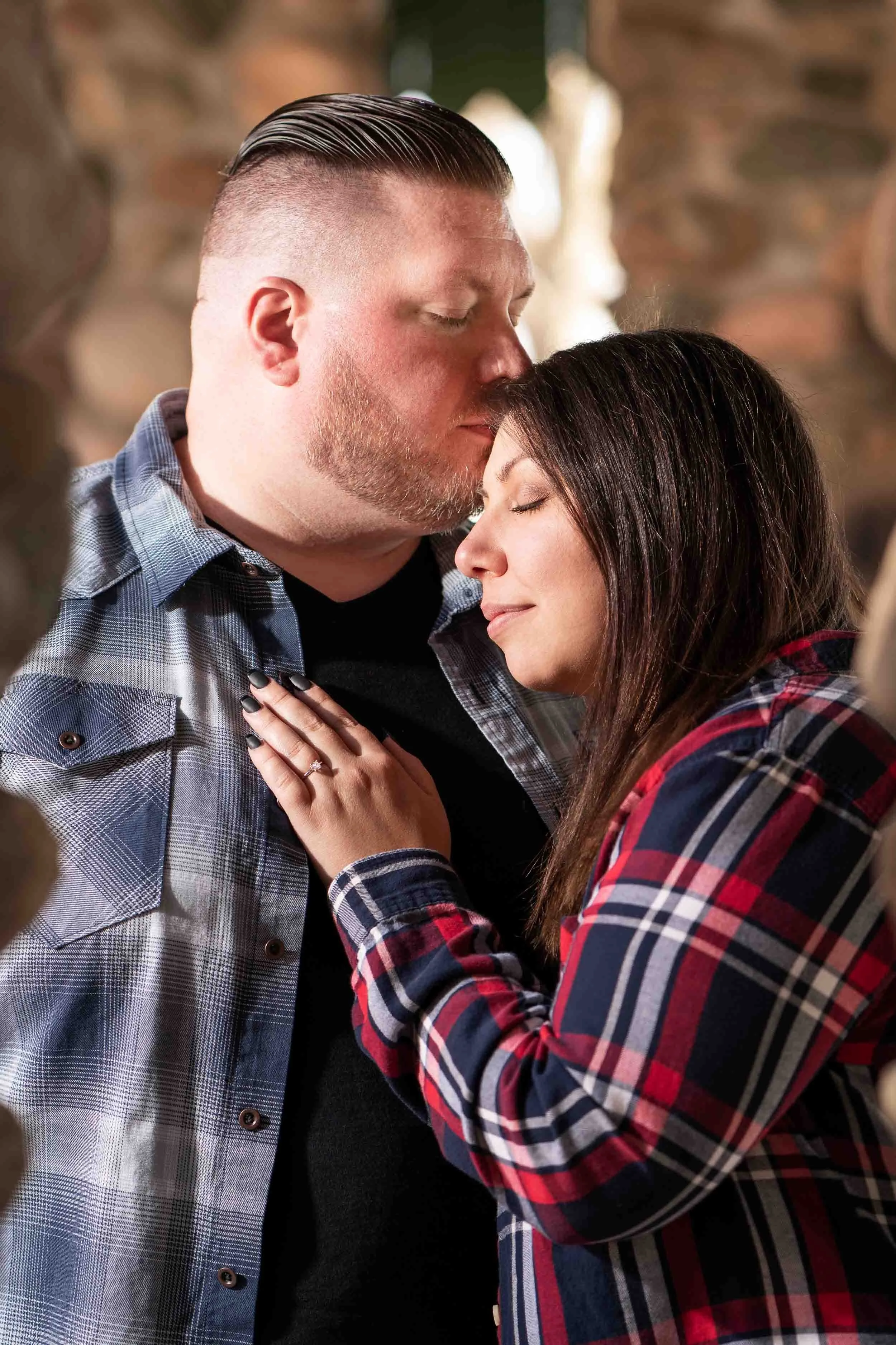 Close-up engagement photography of a couple in flannel shirts sharing an intimate moment in Northern Indiana, shot by James Russell Photography.