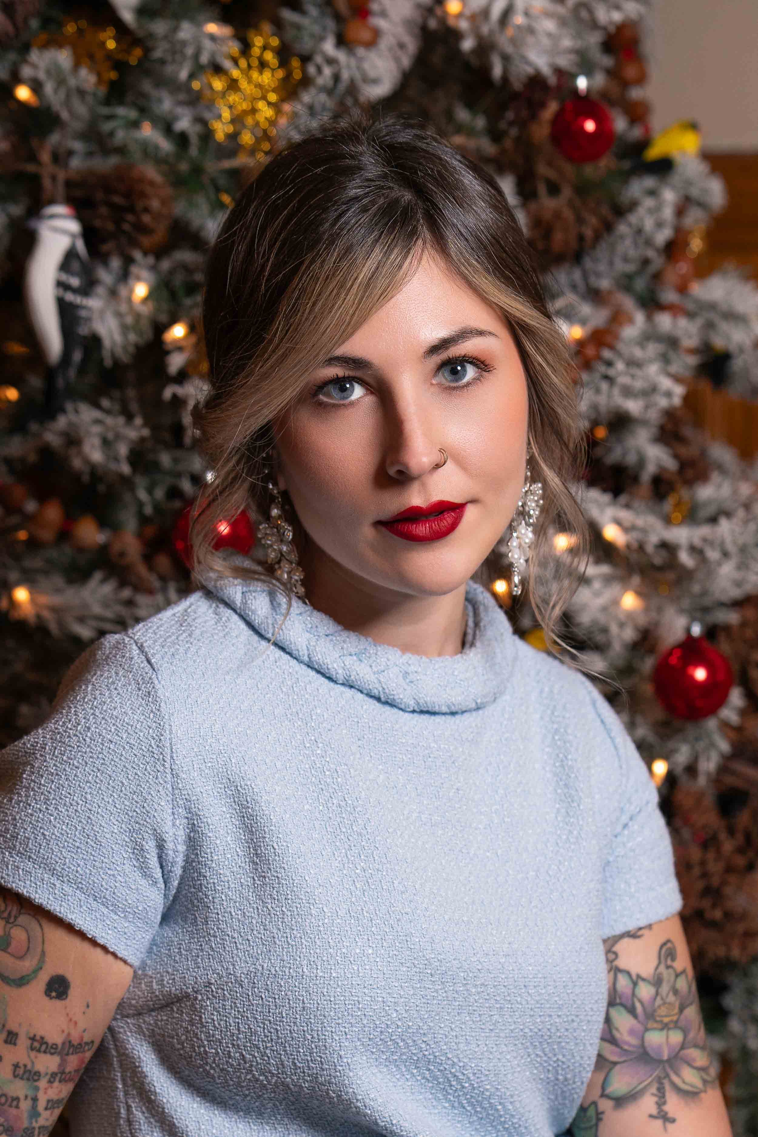 Professional studio holiday portrait of a woman in front of a Christmas tree, taken by a South Bend, Indiana photographer.