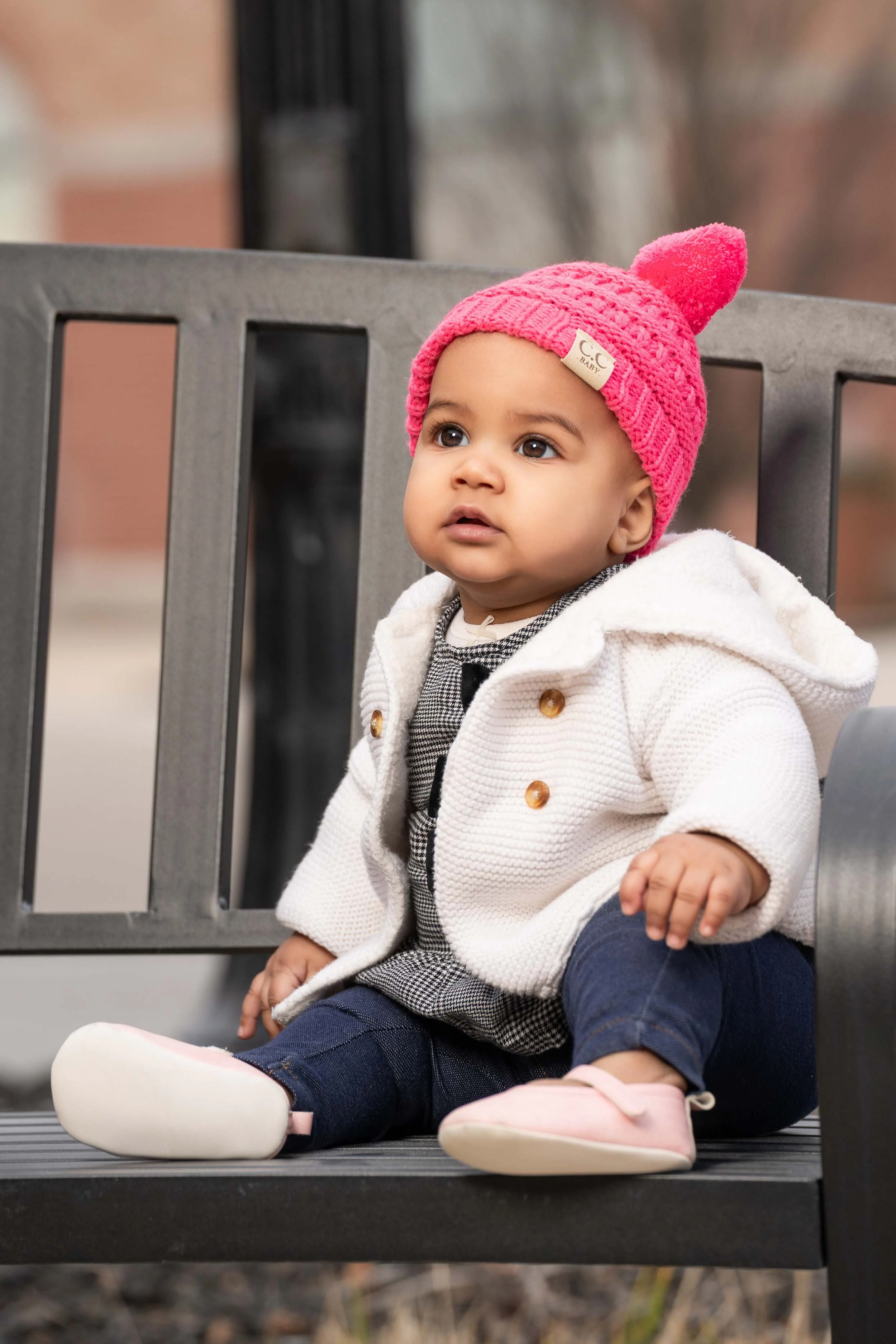 Lifestyle infant and baby photography in South Bend, IN, featuring a child on an urban park bench.