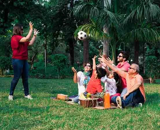 Family enjoying an outdoor game together in a park, highlighting playful movement, connection, and physical activity for family fitness and wellbeing.