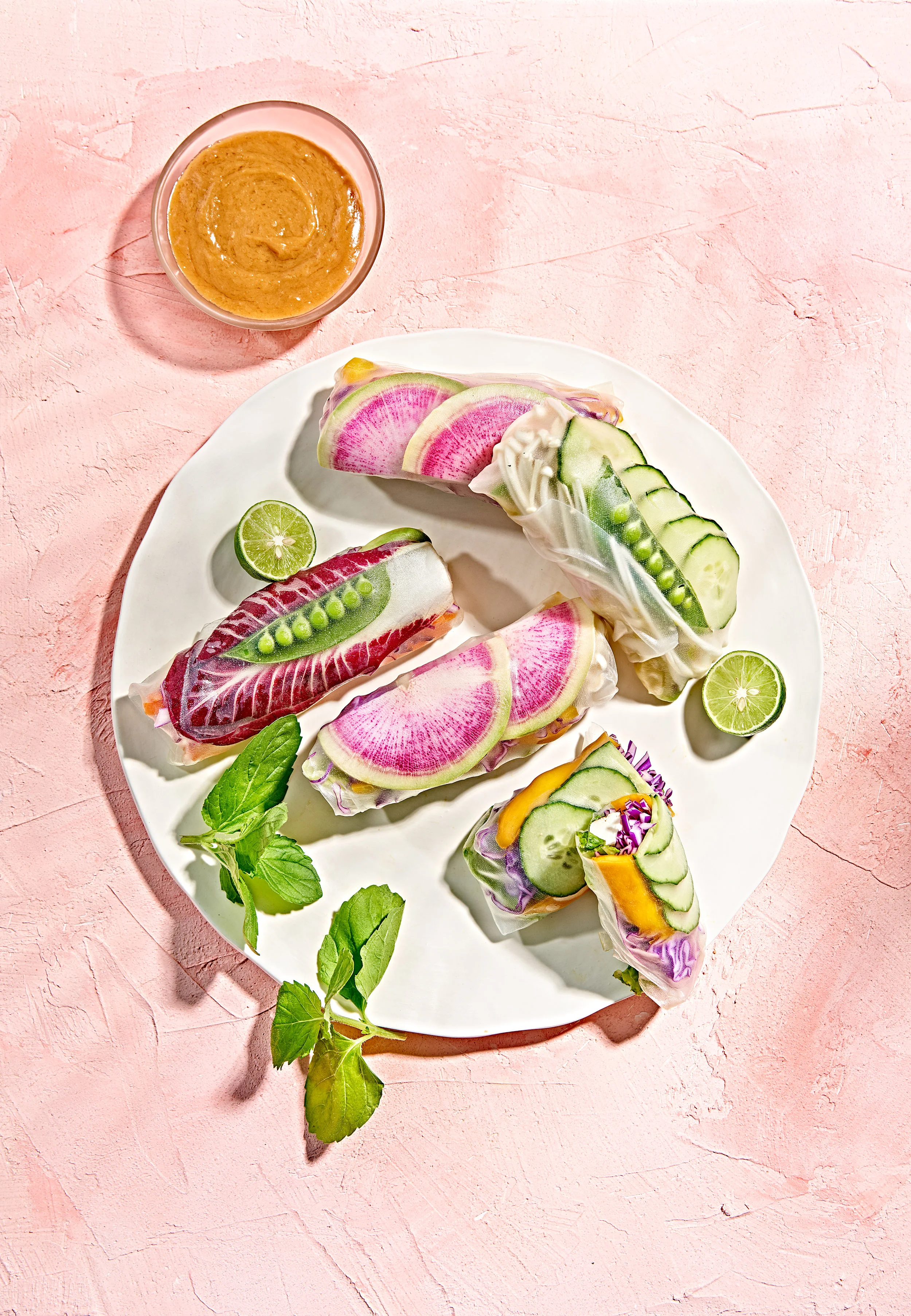 Vegan vegetable and tofu spring rolls on pink plaster background