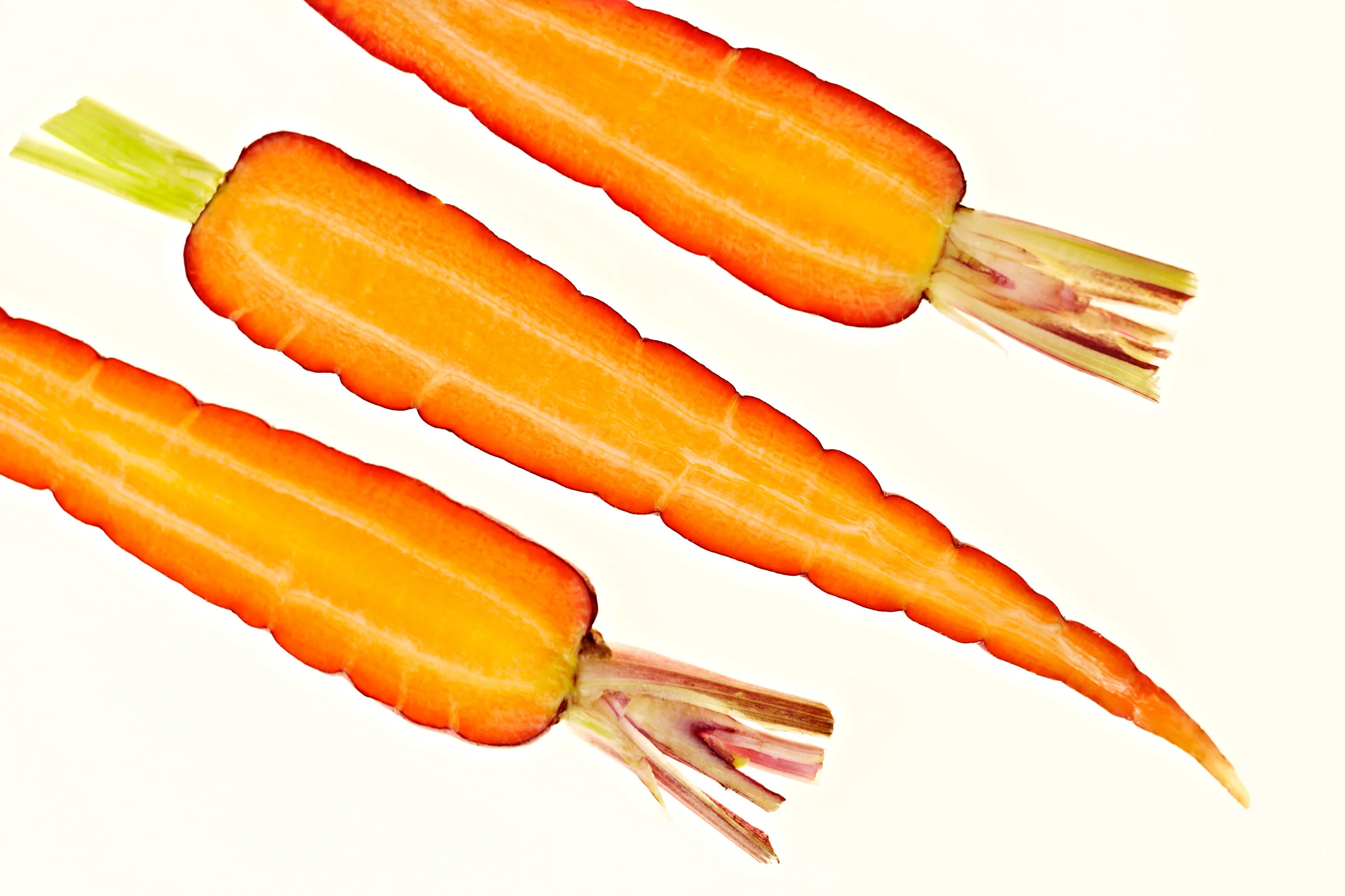 Overhead shot of sliced carrots on white