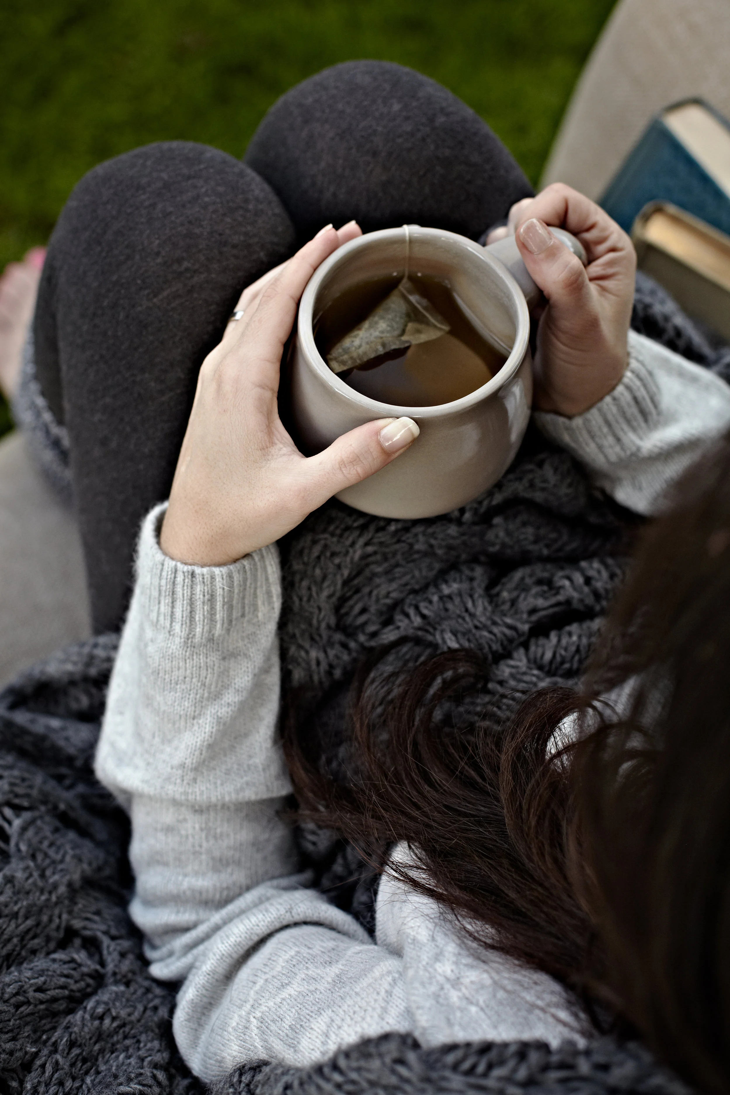 Young woman drinking tea in an armchair outdoors