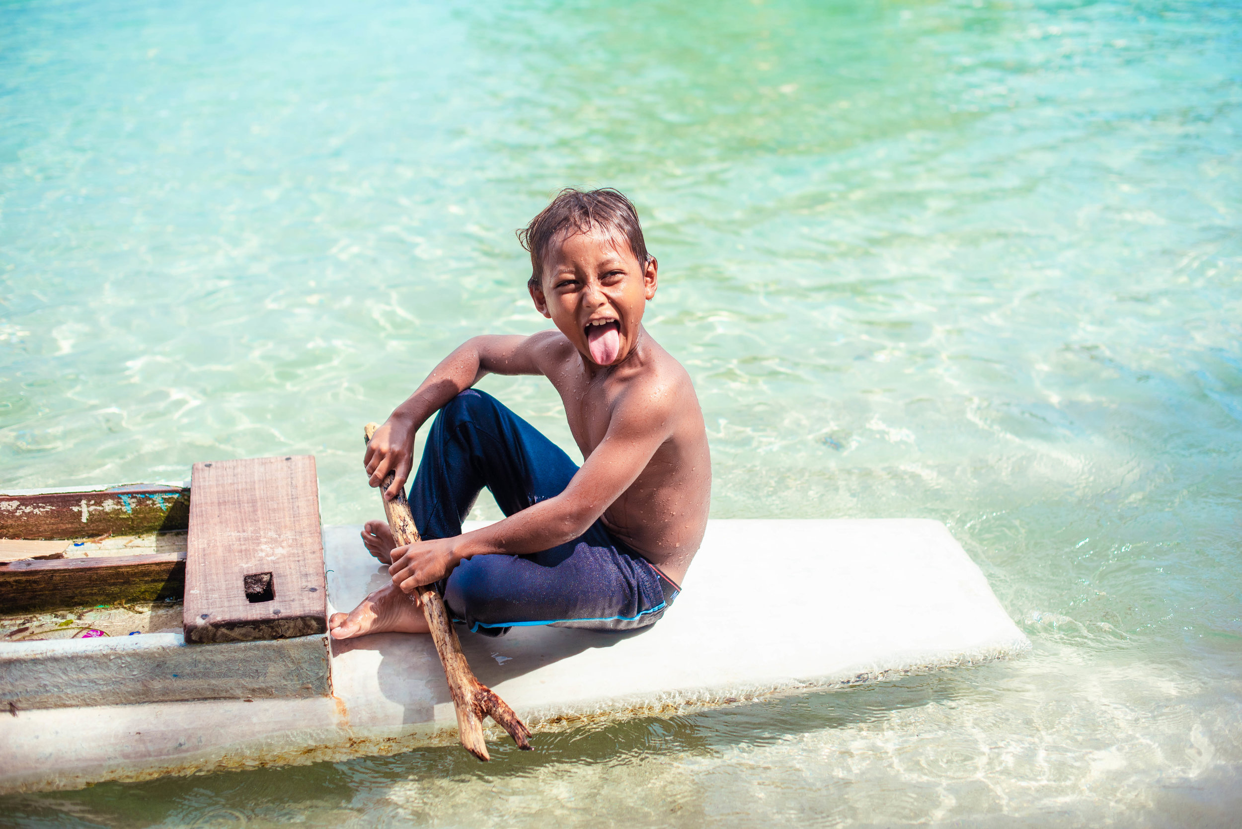  A young boy plays on a paddleboard on a small island in Indonesia. (Image:  Fran Cresswell ) 