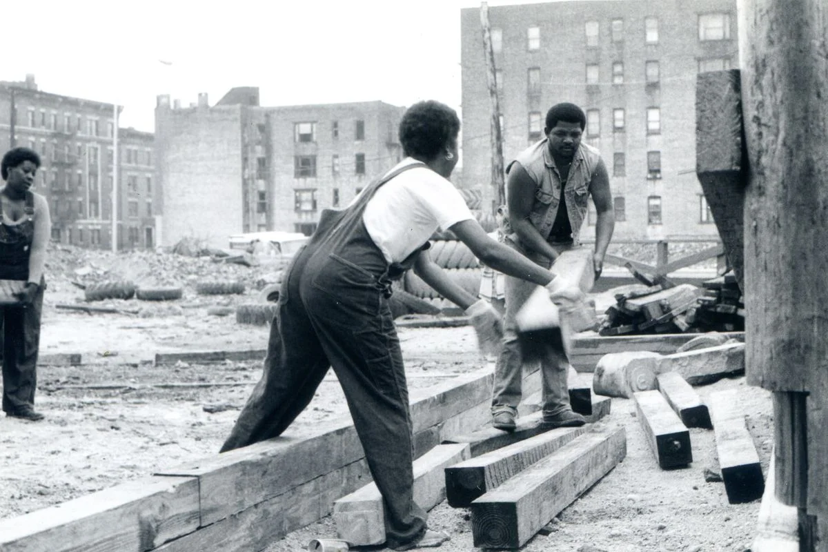 02469_EricWingate_Woman_and_Man_carrying_wood_pillar_b_w.0.jpg