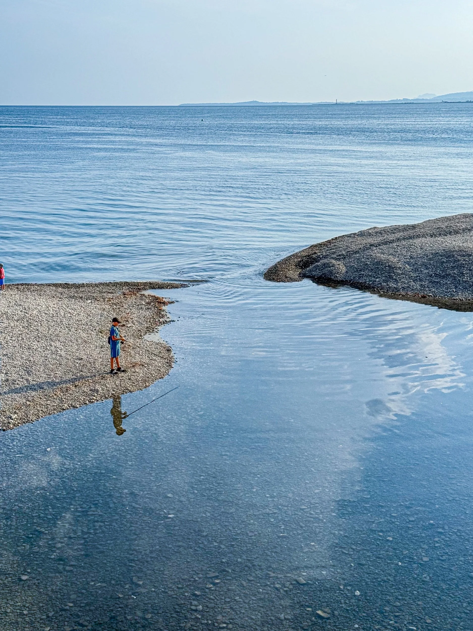 Boy fishing next to the Plage Beau Rivage, Nice