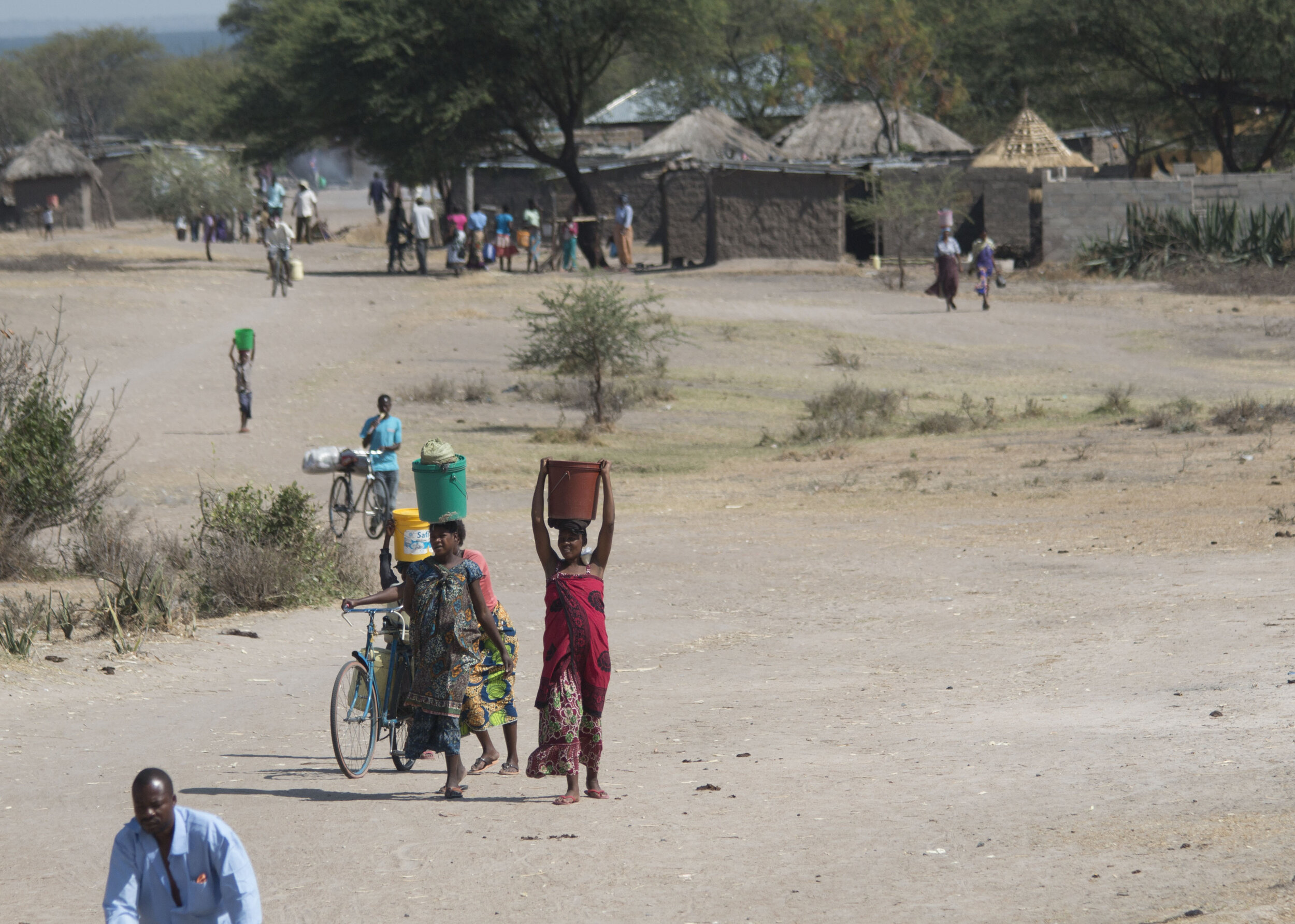 Carrying water buckets thru village.jpg