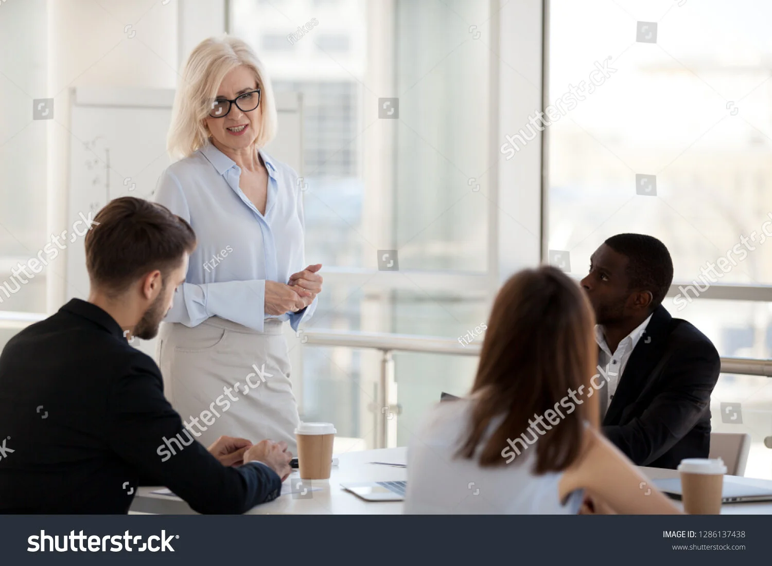 stock-photo-diverse-workers-sitting-at-desk-listen-experienced-coach-company-owner-female-boss-businesswoman-1286137438.jpg