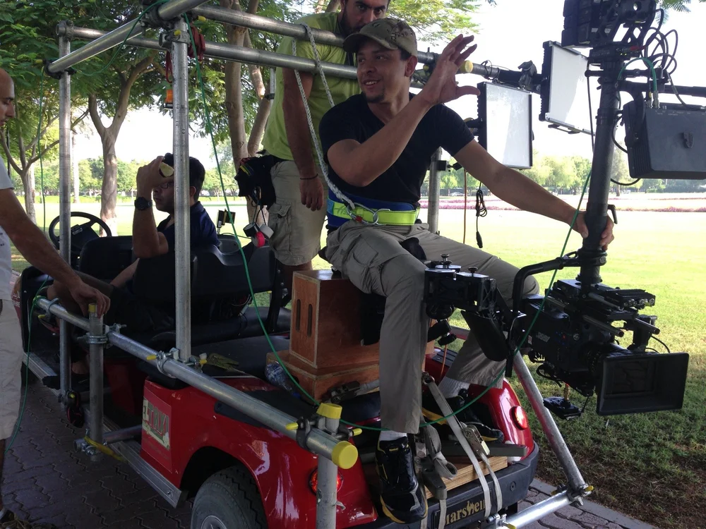 Camera crew preparing a rig on a golf cart