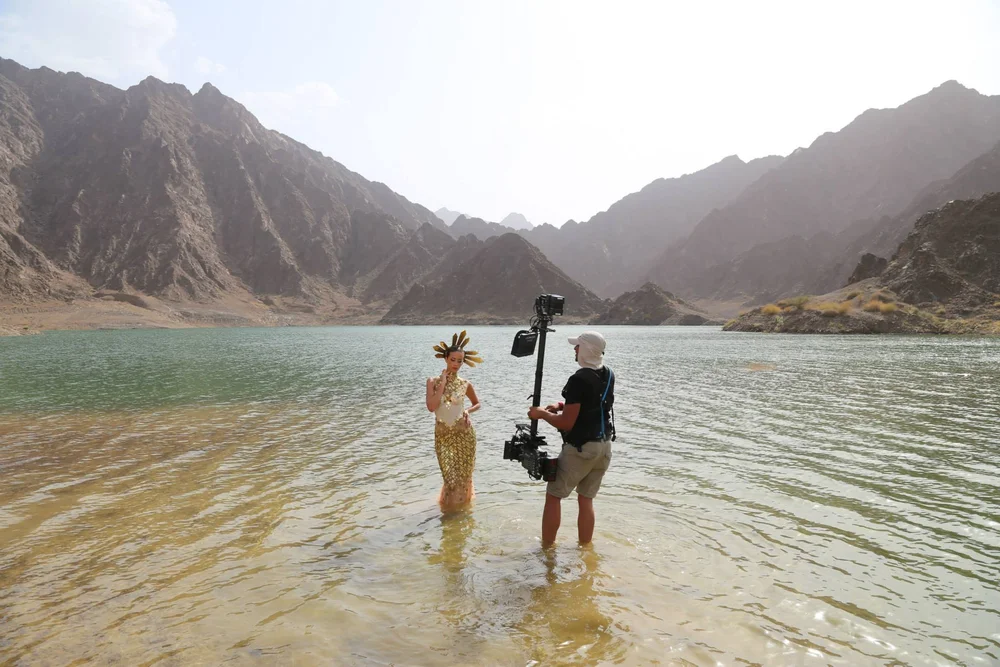 Camera operator and crew filming beside the coast