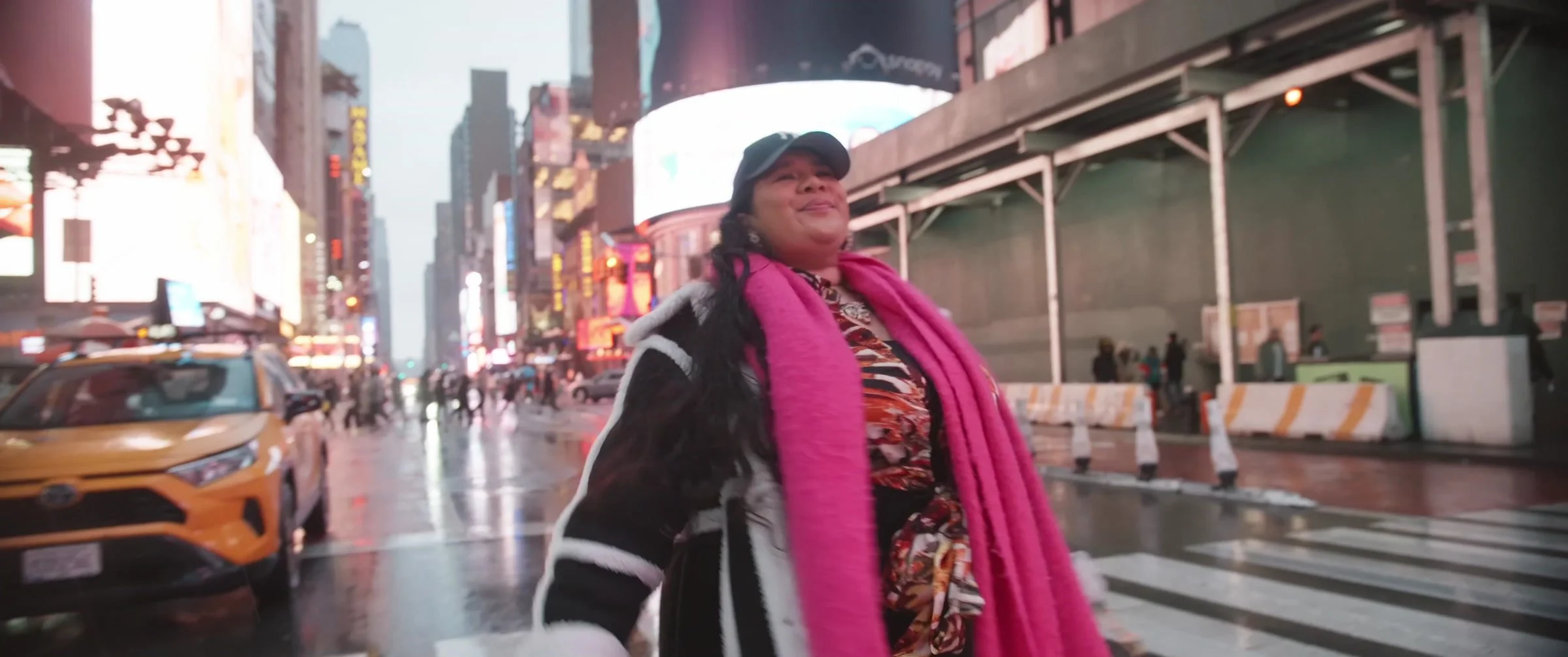 A woman in a pink scarf in New York City, from the Moonlighting documentary trailer