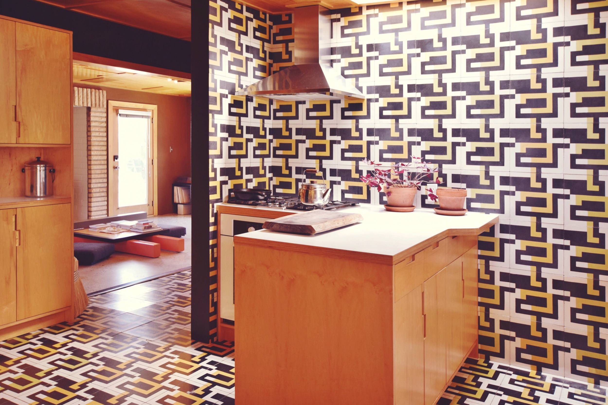 The kaleidoscopic kitchen featuring Andrea’s custom tiles and work benches. A reluctant diner, Andrea lived without a stove for many years, cooking instead together with her guests on a communal hot plate similar to a Korean BBQ.