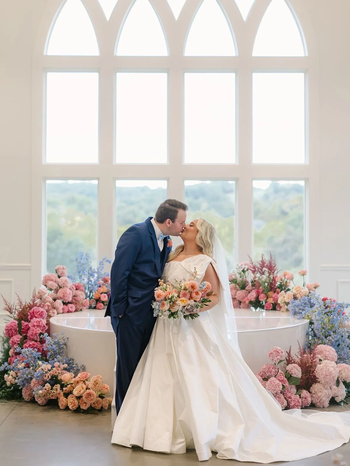 Bride and groom kiss in front of wedding ceremony altar