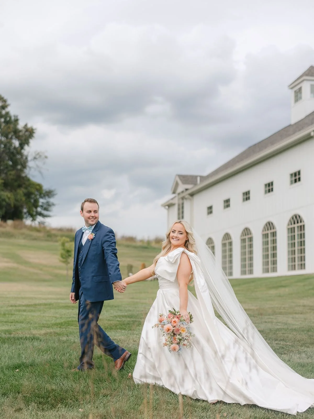 Bride and groom hold hands and walk outside Westwind Hills