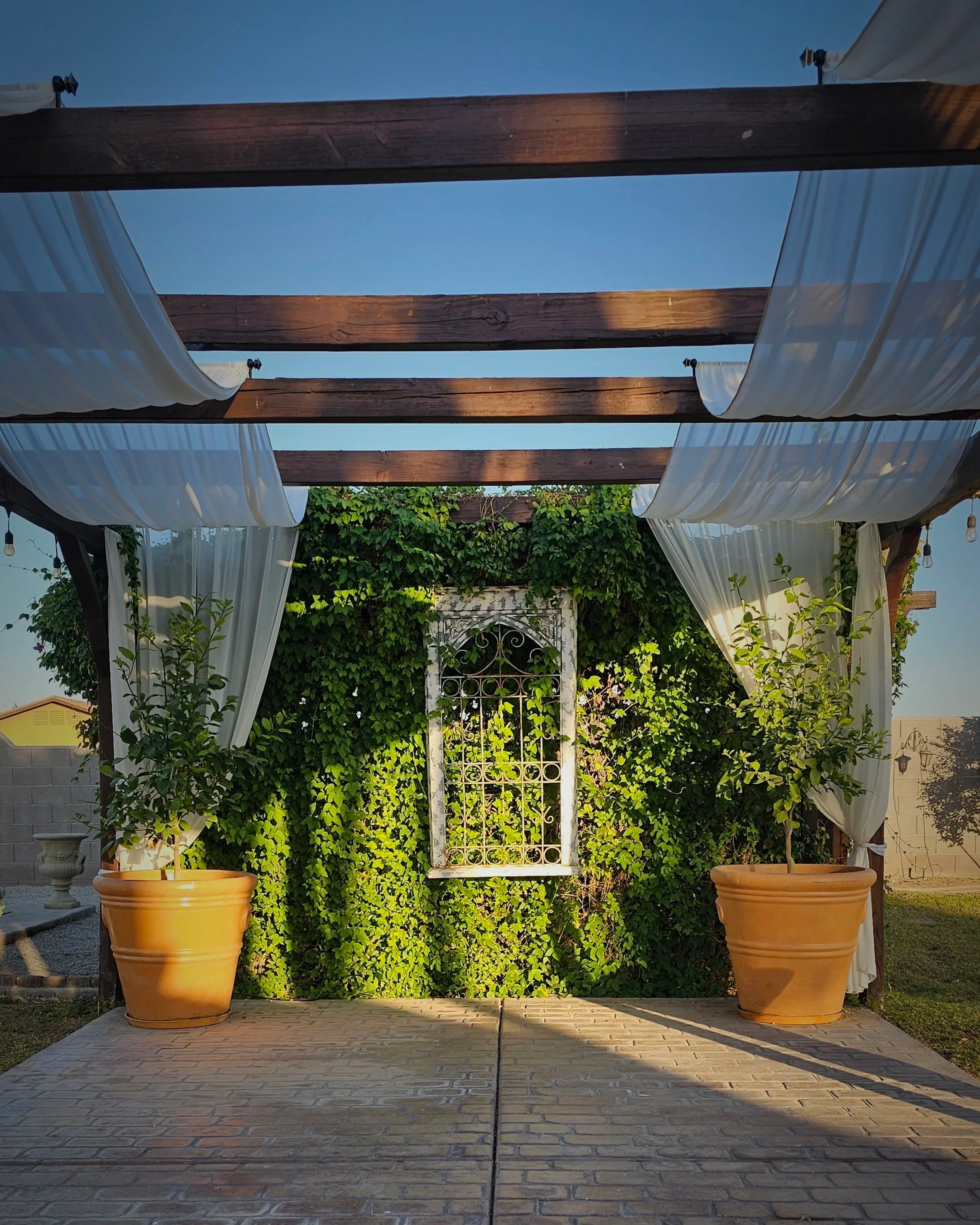 Tuscan-inspired pergola and ivy courtyard at Villa de la Meza during golden hour.