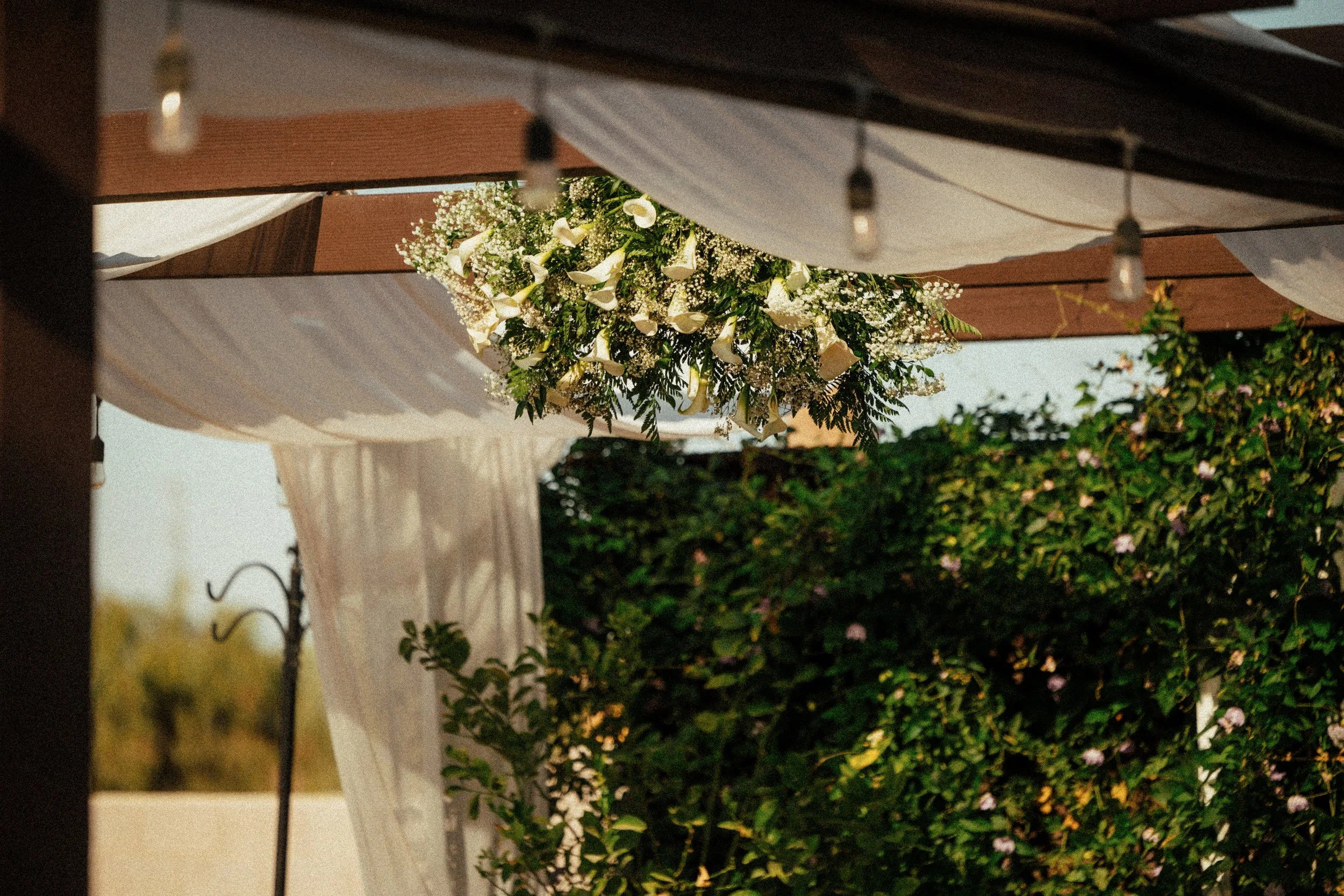 Wedding ceremony floral arrangement framing the aisle at Villa de la Meza.
