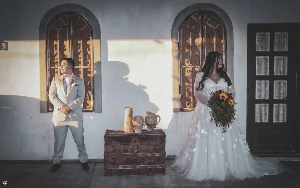 Couple posing beneath the Tuscan-inspired architecture at Villa de la Meza.