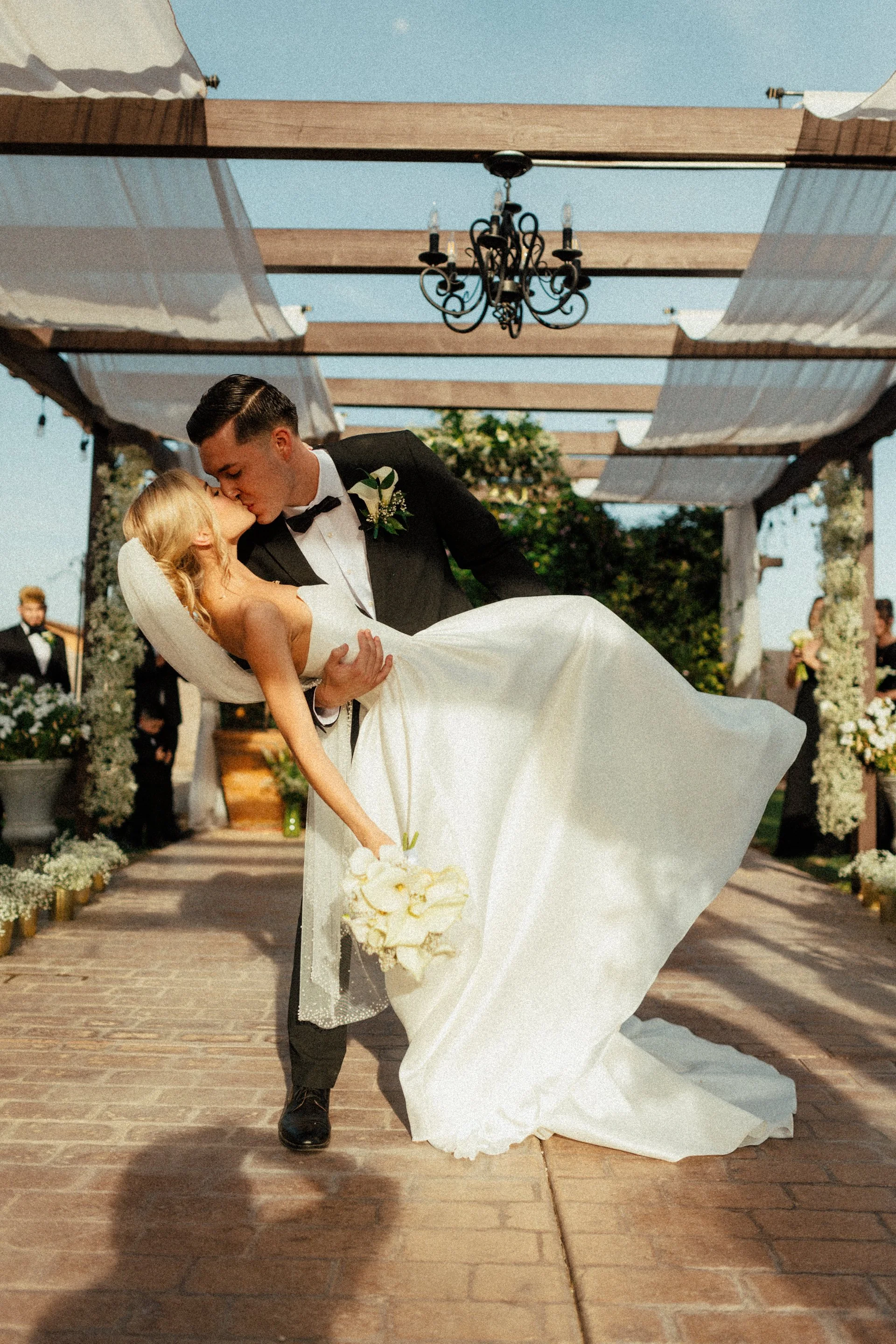 Bride and groom celebrating their first kiss after the ceremony beneath the pergola at Villa de la Meza.