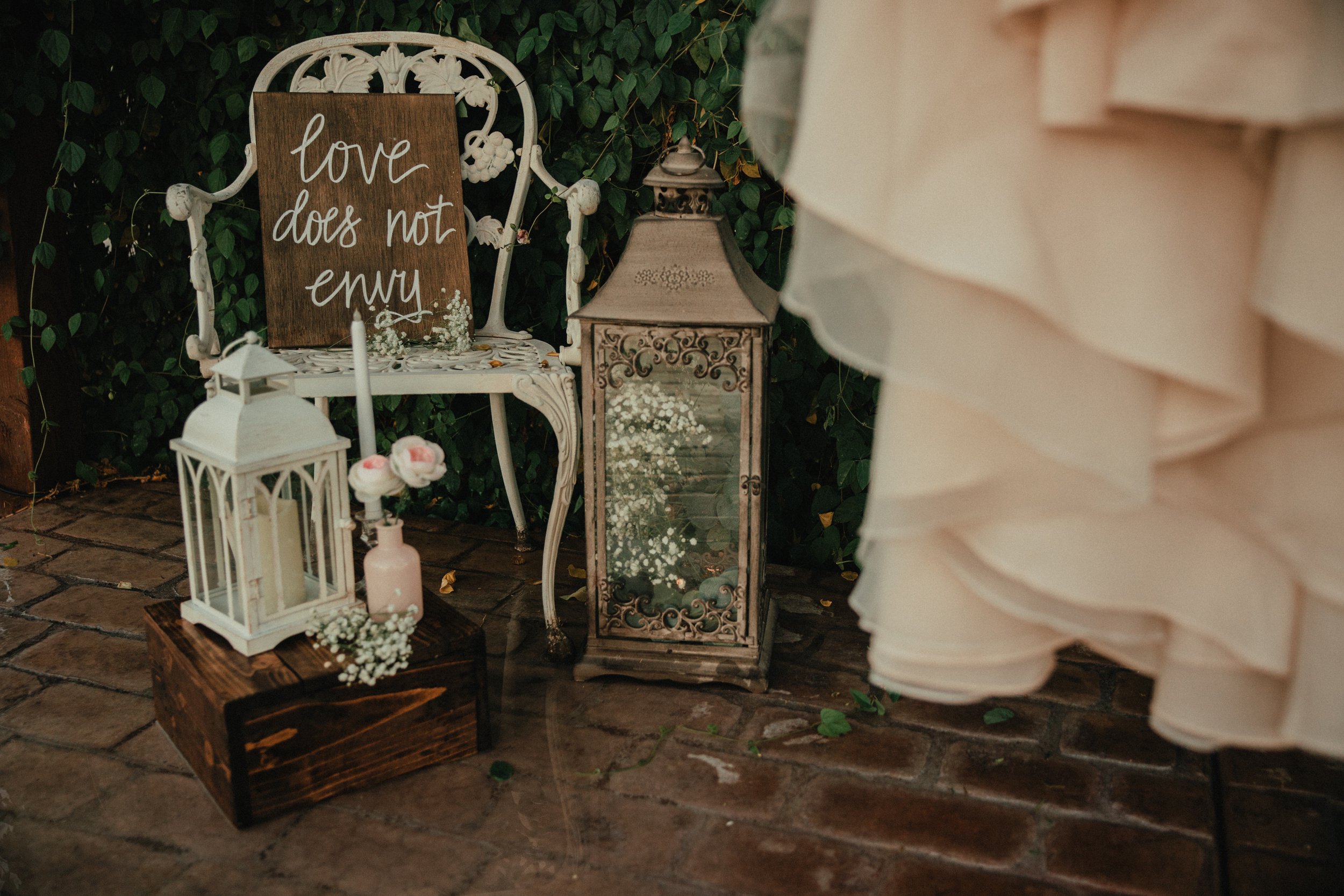 Romantic ceremony décor with vintage chair, lanterns, and floral accents.