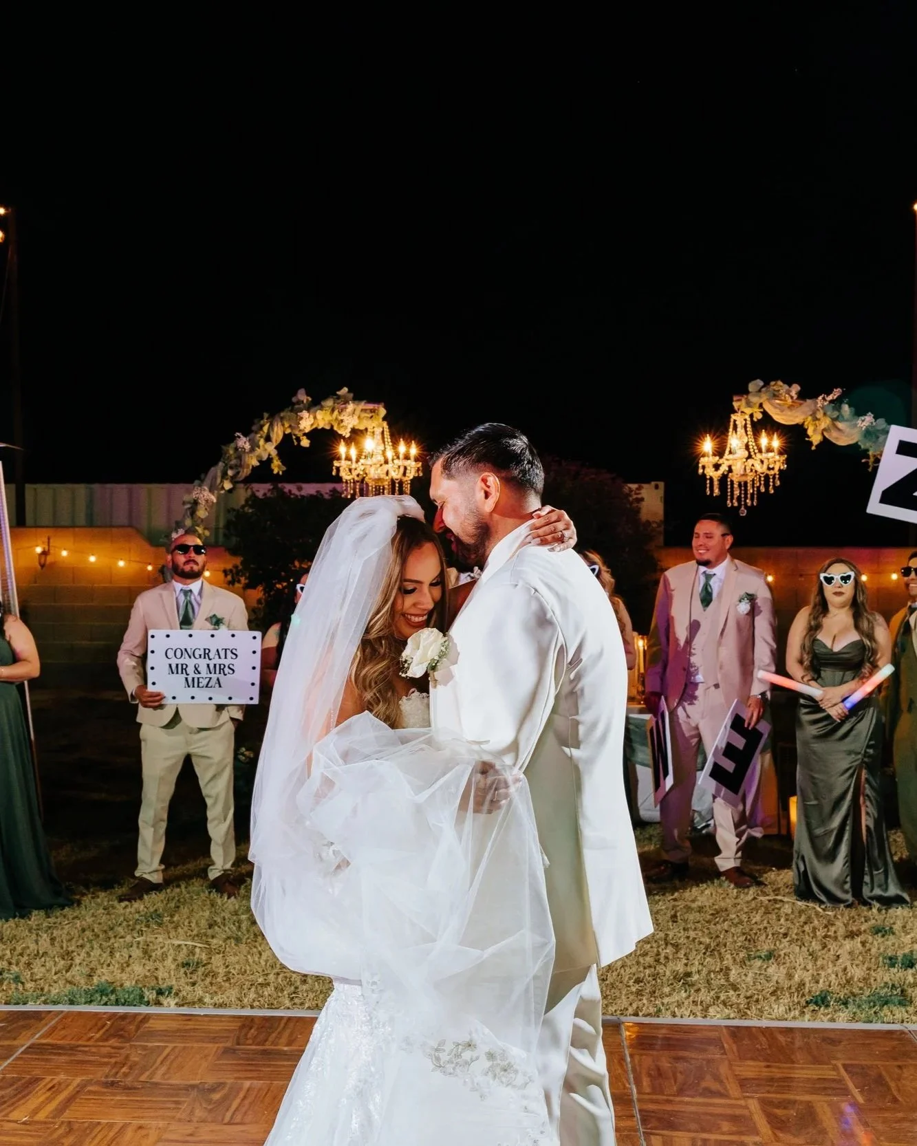 Bride and groom sharing their first dance surrounded by family and friends.