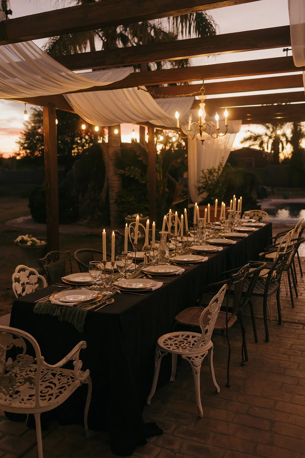 Long candlelit reception table prepared for wedding guests.