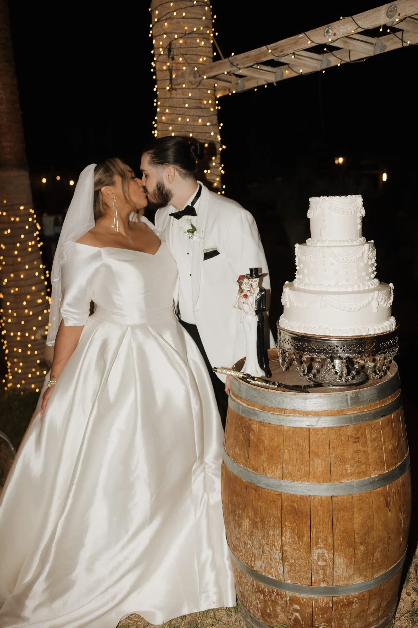 Bride and groom beside their wedding cake during the reception.