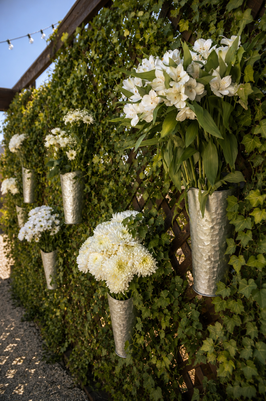 A floral arrangement of white flowers with green leaves amidst dried brown foliage.