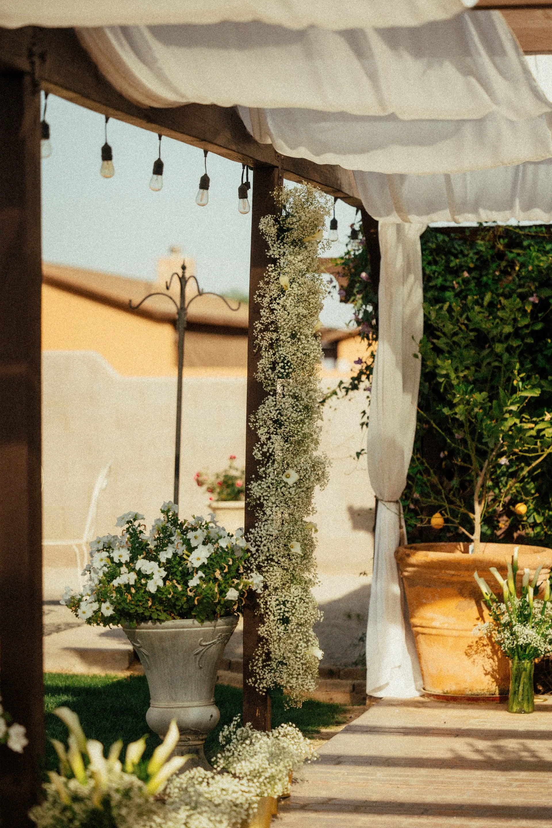Floral ceremony décor beneath the pergola at Villa de la Meza wedding venue in Yuma, Arizona.